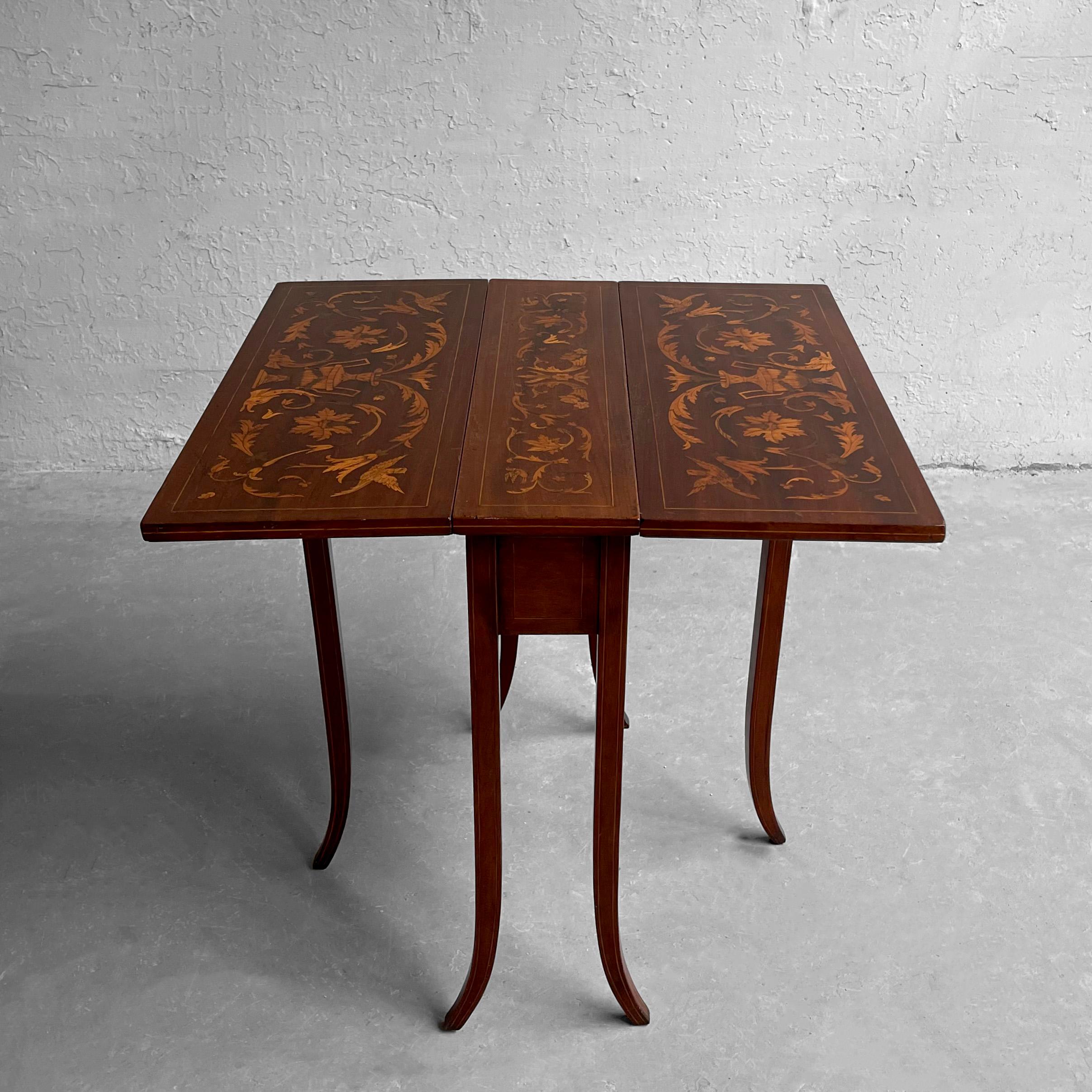 Petite, English Regency, drop-leaf, mahogany side table with symmetrical marquetry, boxwood inlay work and beautifully curved saber legs. The table extends from 7.5 - 26 inches deep with a drawer for storage.