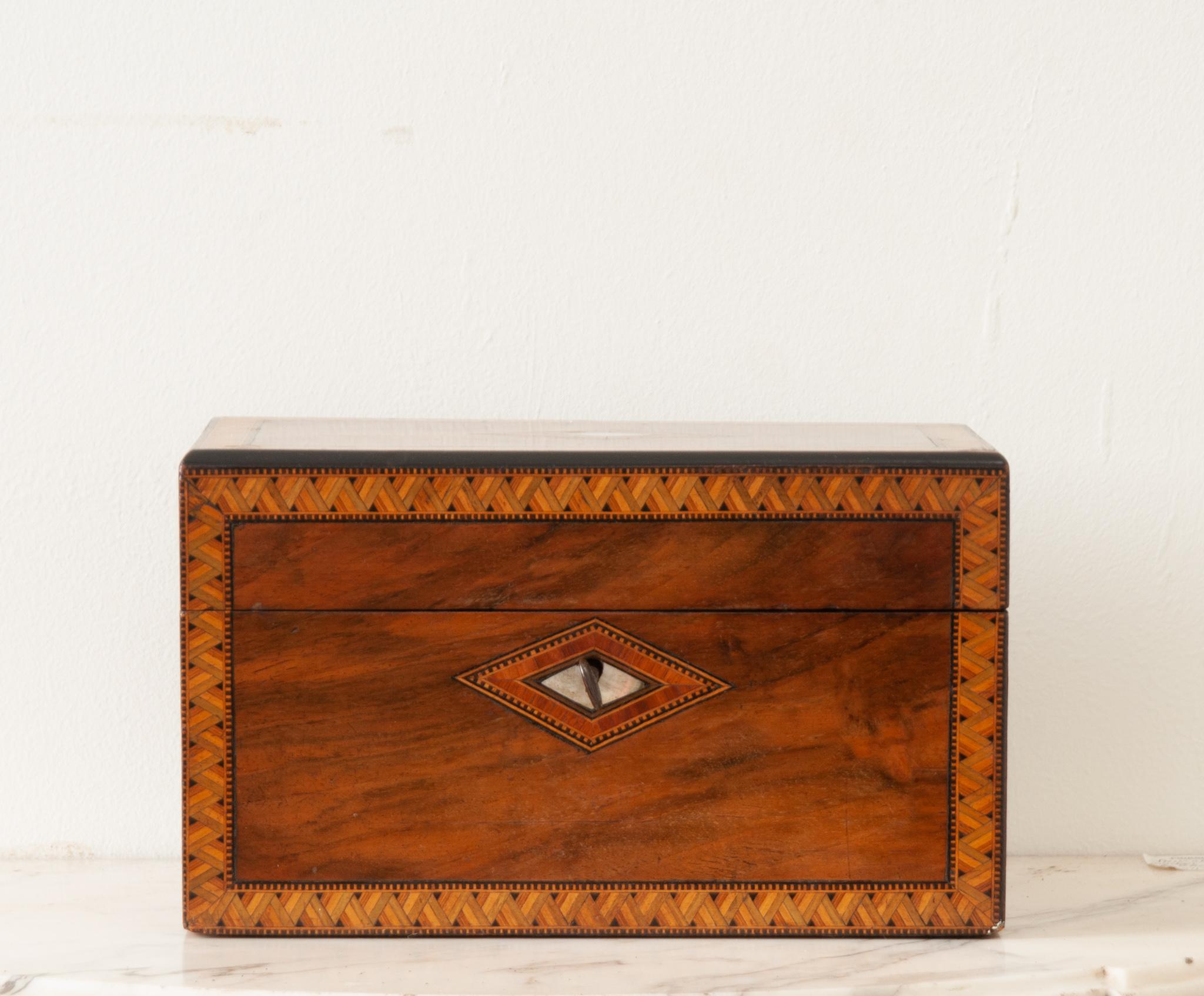 An English 19th Century mahogany tea caddy with diamond shaped mother-of-pearl inlay surrounded by a marquetry pattern of satin wood, mahogany and ebonized wood. The top and the front facade of the box are surrounded with geometric marquetry