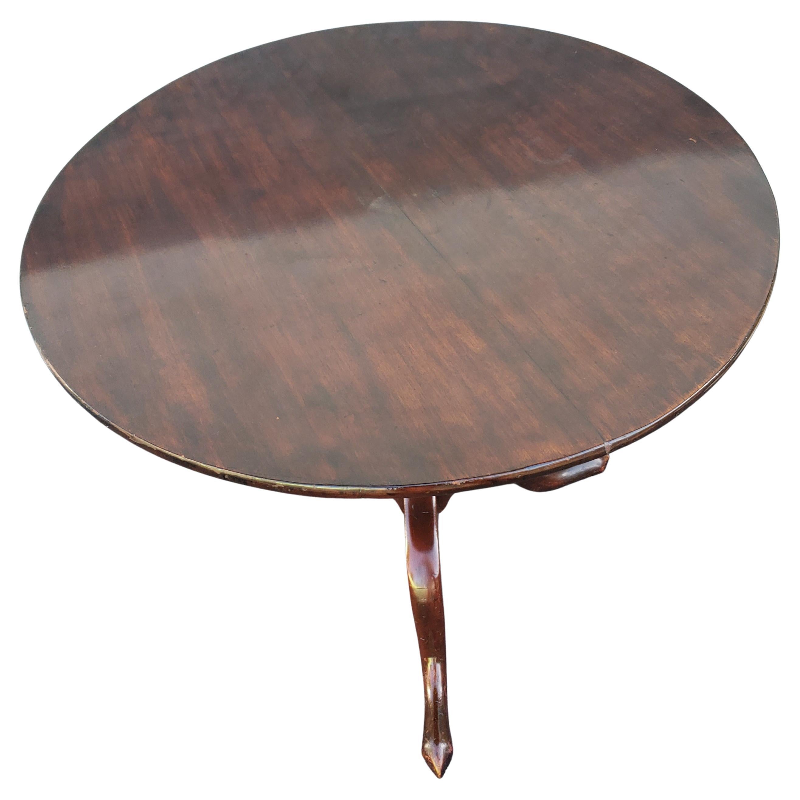 English mahogany one board tilt top tea table, dessert table. Come with its original banjo locking mechanism. Pedestal with turned ringed spiral and terminating on tripod legs with slipper pad feet, Mid 18th Century. Measures 32