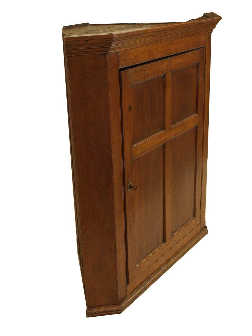 English mahogany one door hanging corner cupboard with cove cornice, the single door with four panels, interior with 2 shelves, working lock and key. Depth and width measurements are taken from the cornice, the depth from the side to the back corner