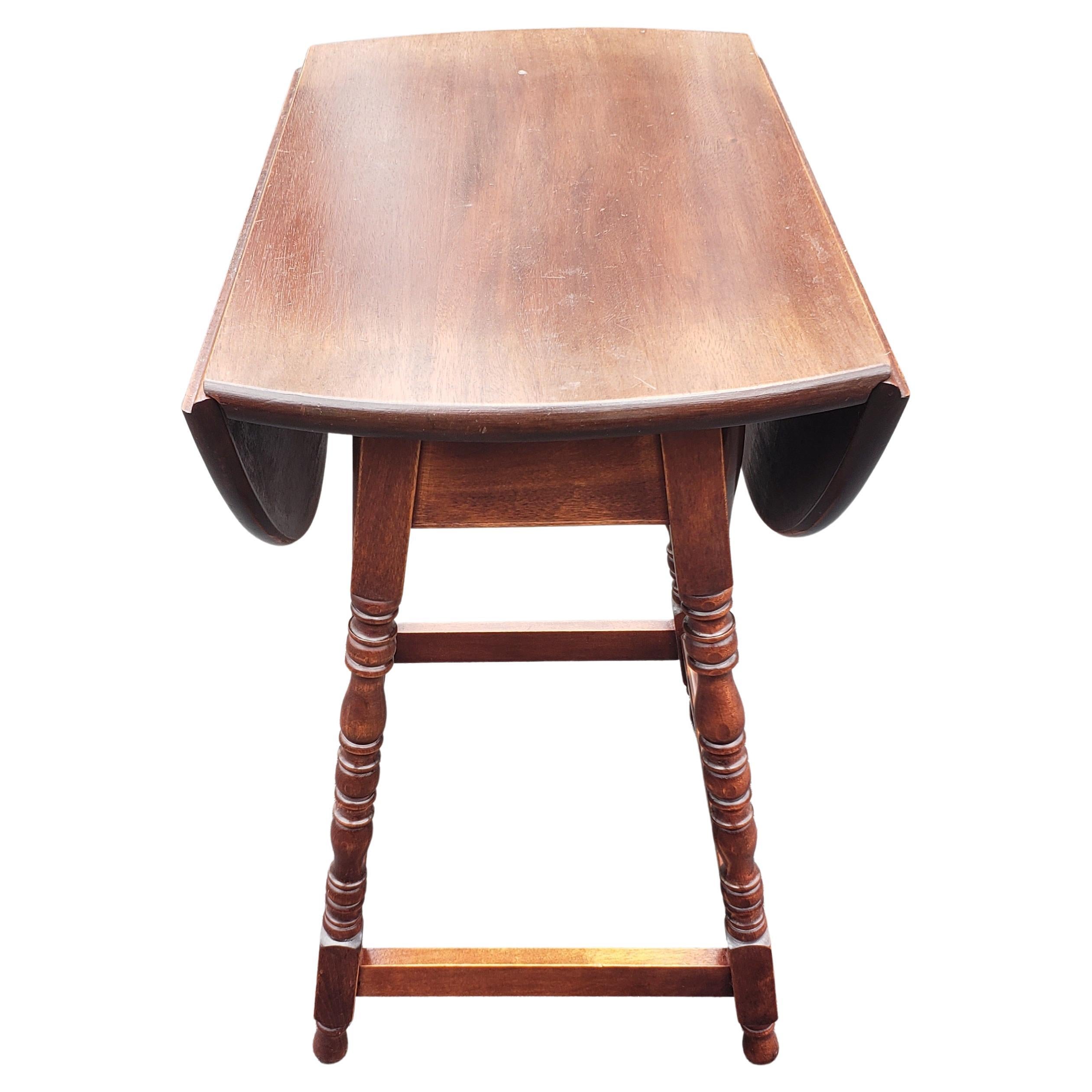 English mahogany oval drop leaf side table with bobbin legs. Very good vintage condition. Measures 14