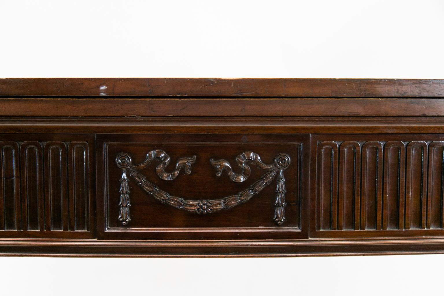English mahogany serpentine Hepplewhite console table or server has fluted front legs terminating in Marlborough feet. The top lifts to reveal a surface covered with baize. The apron is fluted and has carved oval medallions flanking a center panel