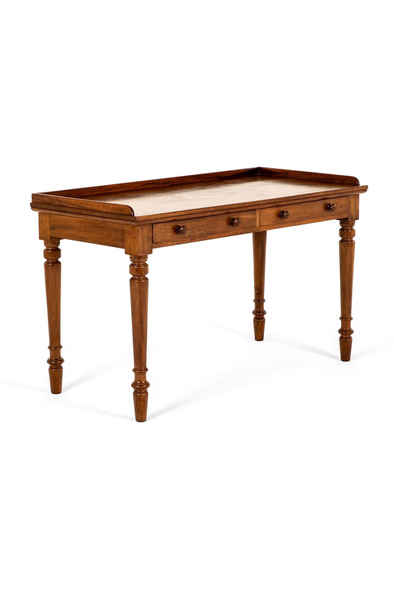 A Victorian mahogany side or serving table with a shallow rectangular three-quarter gallery.

Below a pair of smooth running frieze drawers on slender turned legs.

The table is of a good manageable size in good country house non-restored