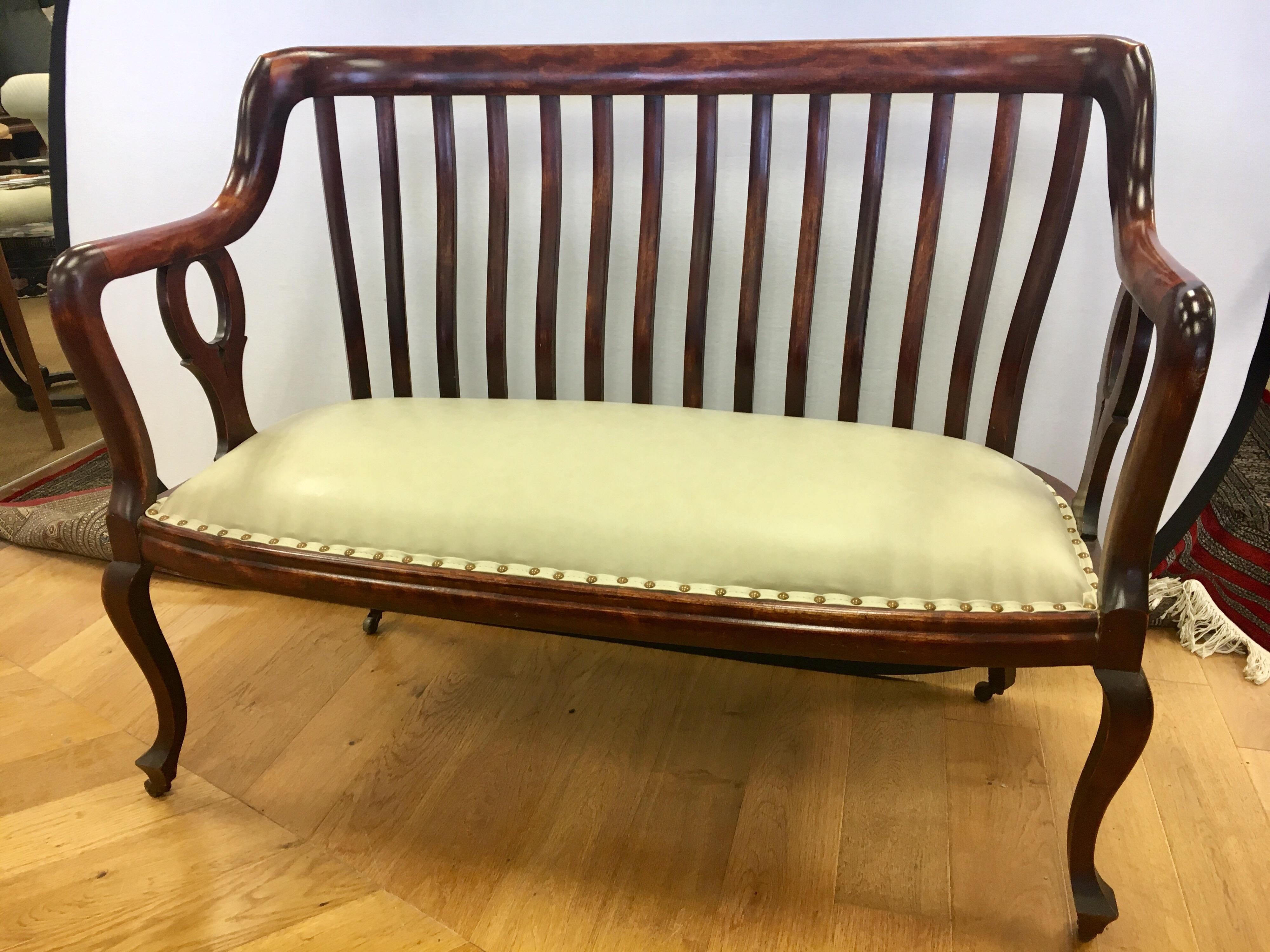 Elegant antique English mahogany settee on casters and featuring brand new leather-like upholstery and
fill for seat cushion and nailheads throughout. The nicest settee online today, in our humble opinion!