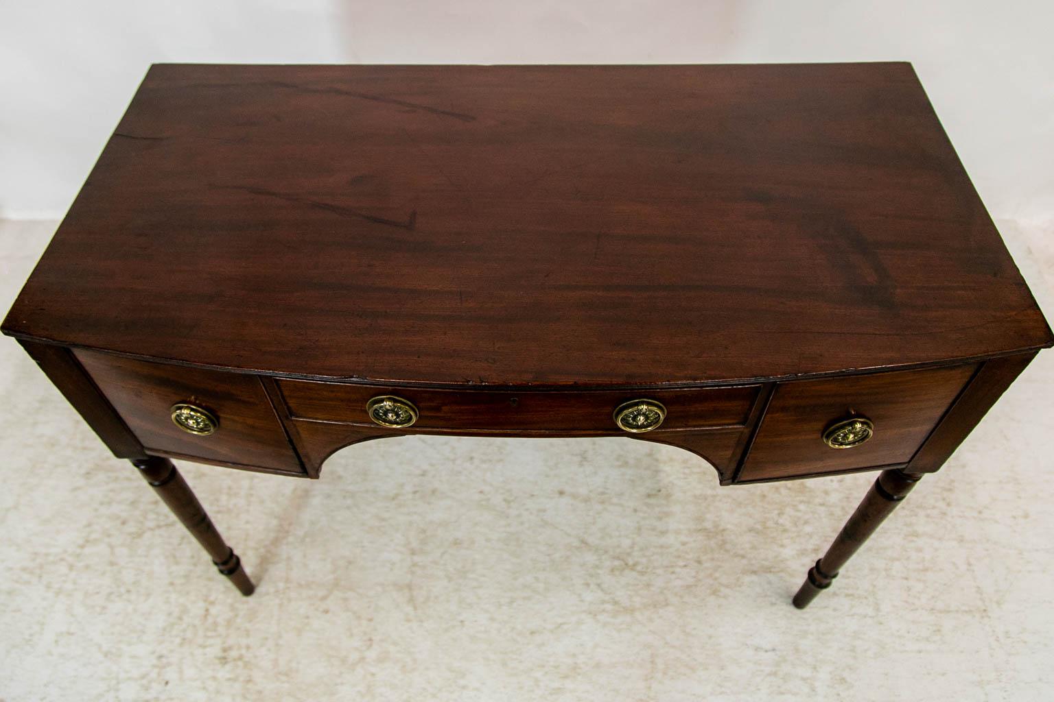 The drawers of this server have cockbeaded edges. The center drawer has an arched apron below. The top has a carved tripled reeded edge on the front and sides.