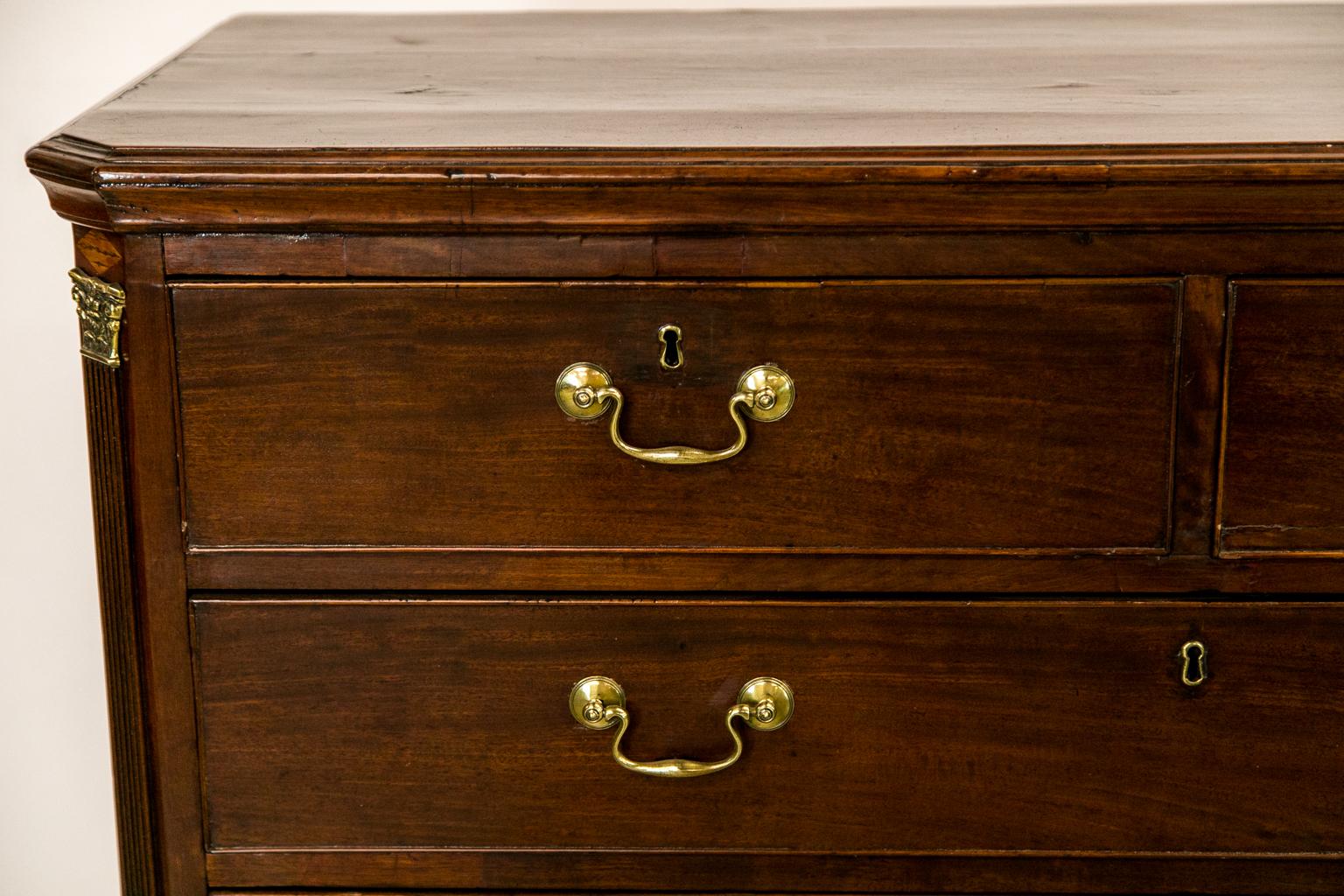This English mahogany chest has two drawers over four drawer graduated drawers, fluted chamfered corners with the original Corinthian brass capitals and Ogee bracket feet. The ''Swan neck'' hardware is original.