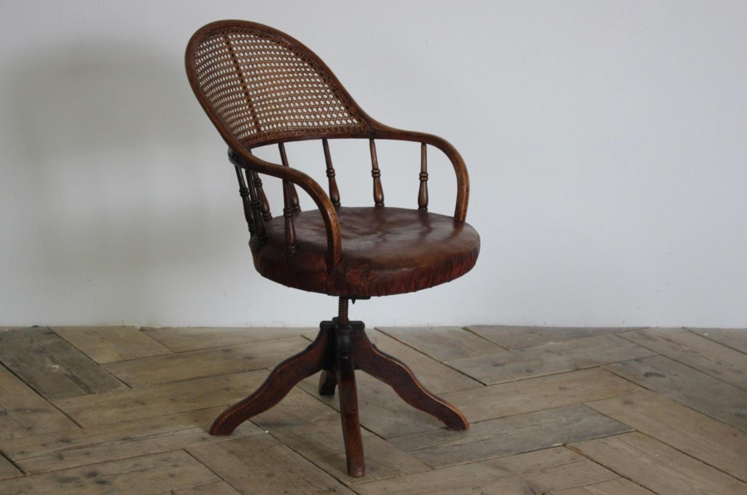 English mahogany swivel desk chair with original auburn leather seat and adjustable cane back. Handsome and comfortable. 

England, circa 1890

Dimensions: 37 H x 21 W x 27.5 D.