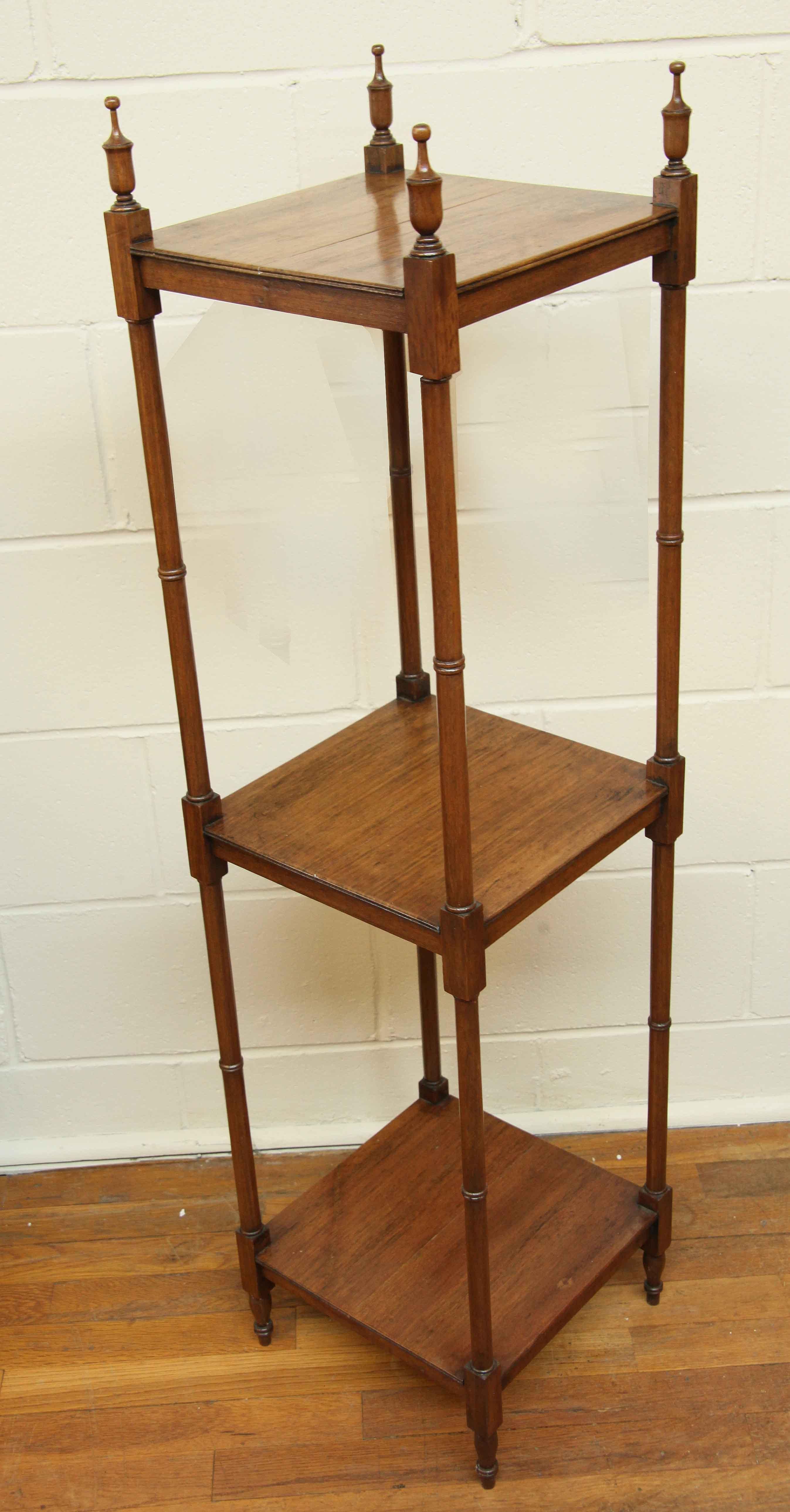 English mahogany three tier etagere,  this square etagere has a beautiful faded color and patina ,  the four corner posts have faux bamboo turnings terminating at the top with baluster shaped finials .  The height to the top of the finials is