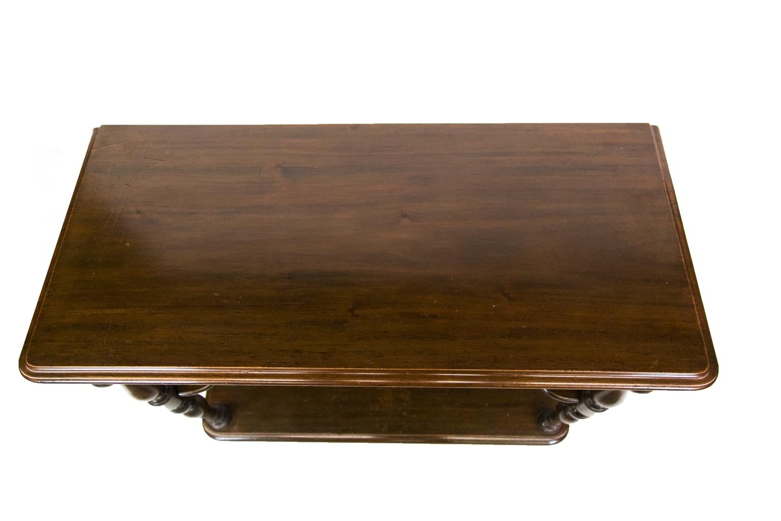 English mahogany three-tiered server has an ogee molded top with turned front shelf supports. The top apron has 1/4” beaded molding, and the center shelf has convex shaping. It rests on a solid plinth base.
 