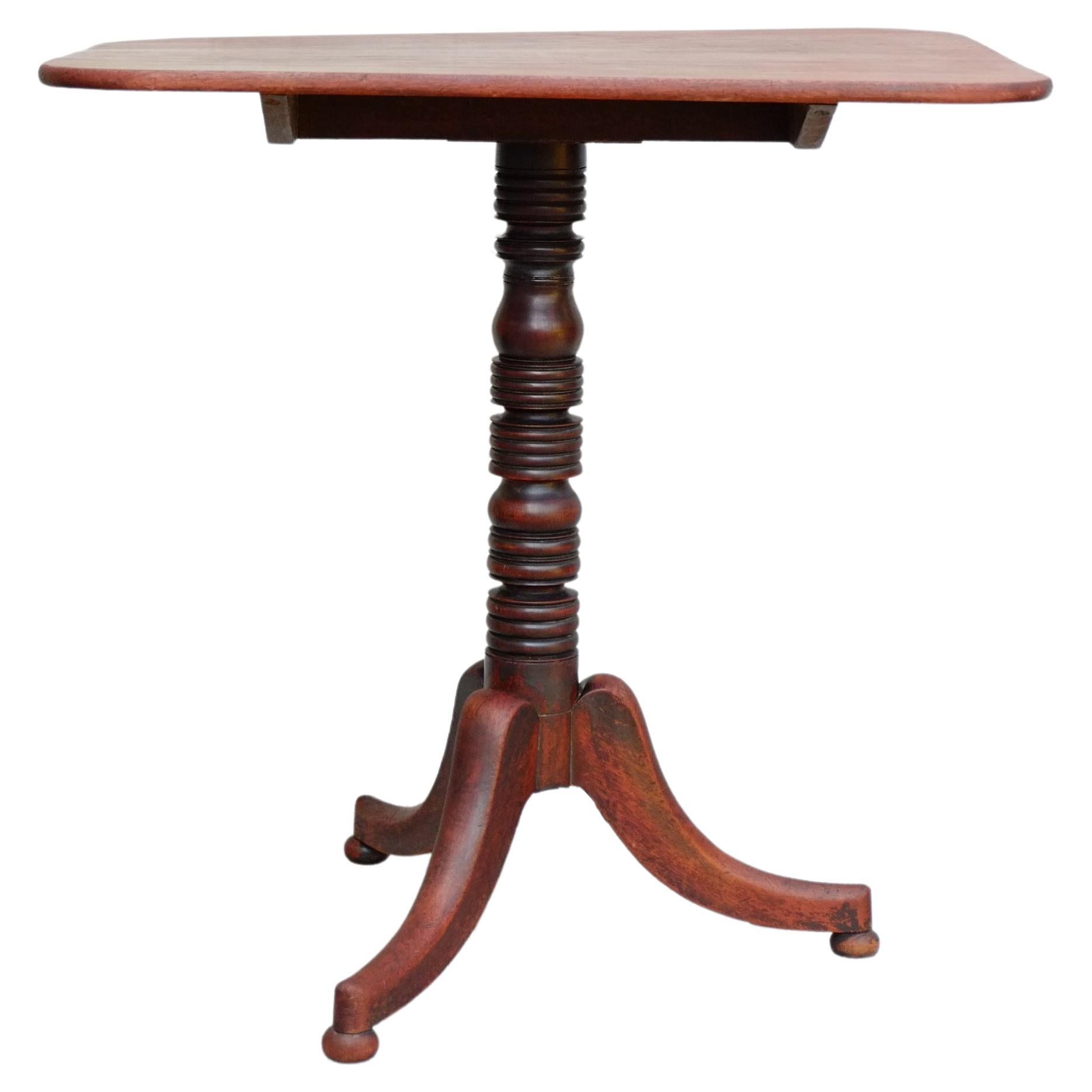 A beautiful English mahogany tilt top table. This table has the most beautiful simple detailing, with a turned bobbin pedestal base on three simple cabriole legs with little bun feet. The table top is a very functional soft rectangle, which makes it