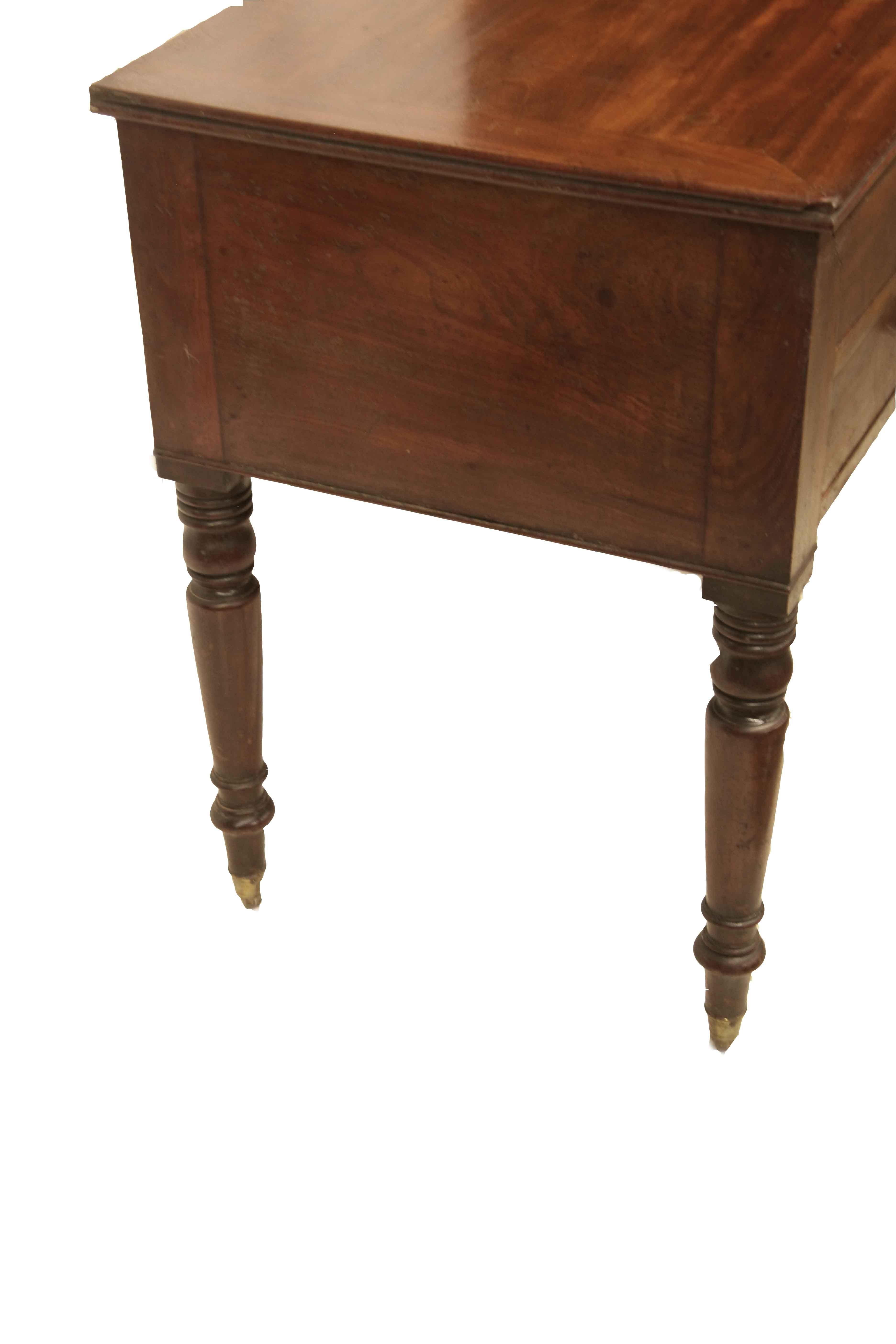 English mahogany turned leg serving table, the top has beautiful color and patina with ''breadboard'' ends. The two drawers over single long drawer provide ample storage. The legs have very pleasant turnings that terminate with brass cup castors.