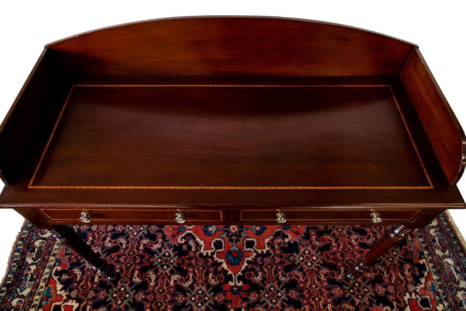 This Sheraton style server has a gallery that has an arched top and shaped sides. The top and drawer fronts are inlaid with Tonbridge style inlay. The finish and hardware are later.