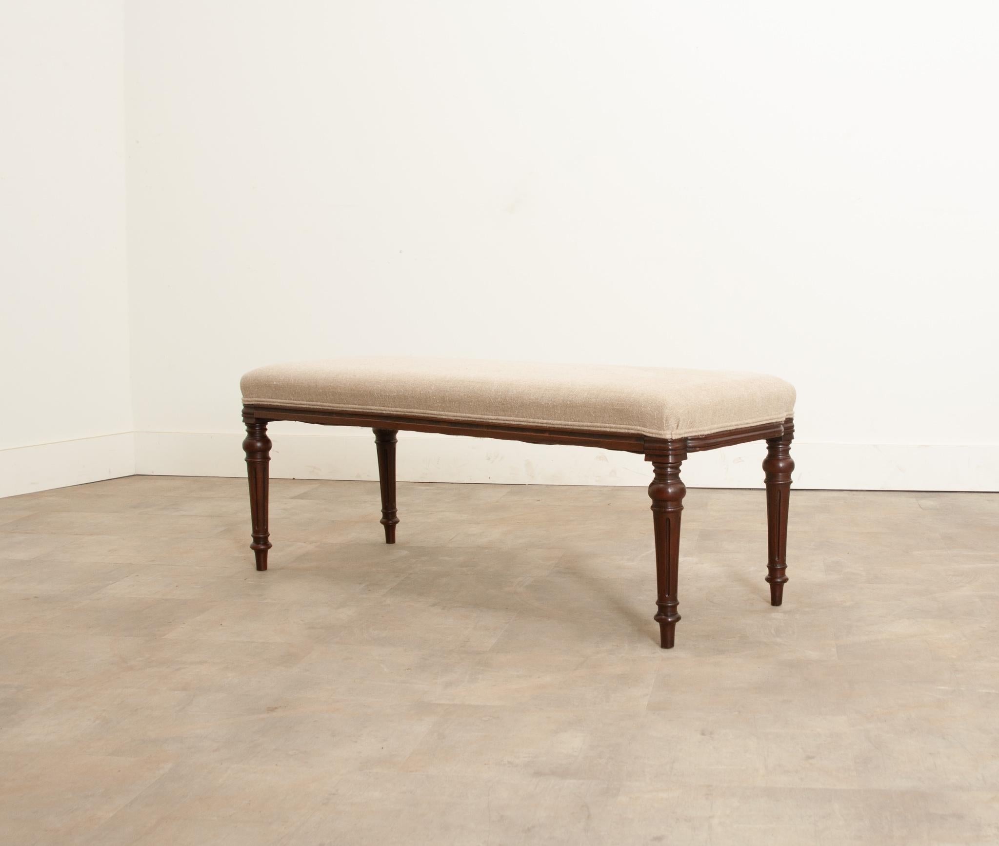 A lovely bench from 19th century England that goes perfectly with any decor style. Recently upholstered in a wonderful neutral fabric with a double welt perimeter. Finley turned, patinated legs continue to support the whole. In fantastic antique