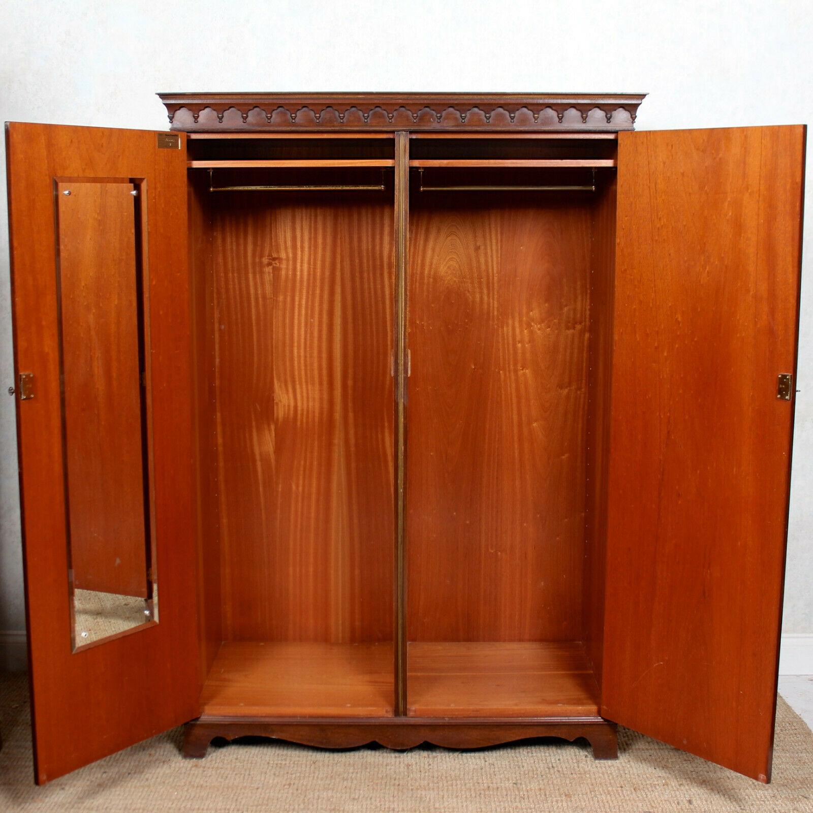 An impressive mahogany double wardrobe by Bevan Funnell.
The top with a carved arcadian cornice above double paneled doors and enclosed adjustable shelving and hanging rails, raised on a carved cutaway base and bracket feet.
England, 20th century.