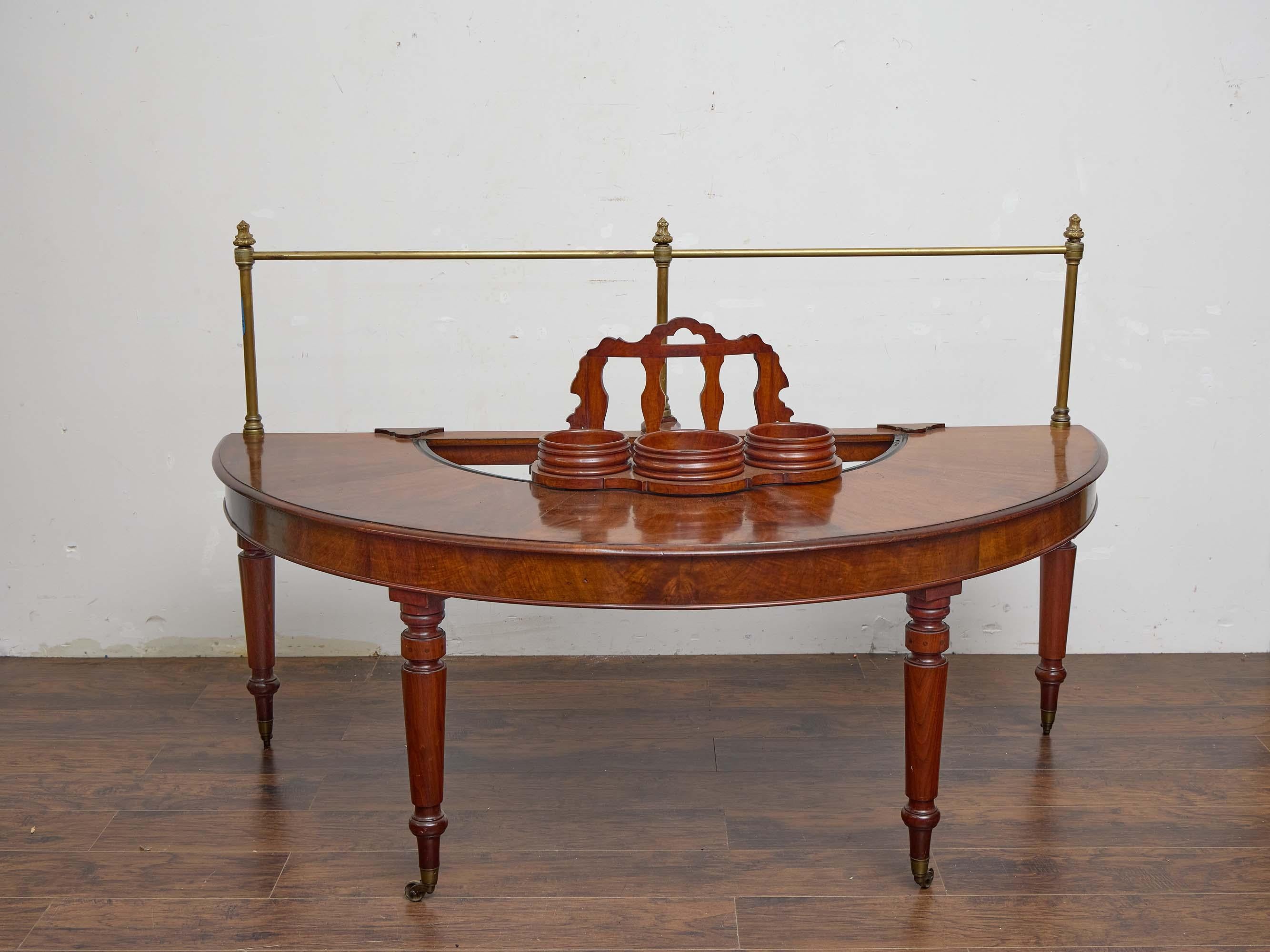 A rare and finely crafted English wig table in mahogany, dating to circa 1830. This unusual semicircular form was designed for the storage and maintenance of wigs, a practice still common in formal and theatrical settings well into the 19th century.