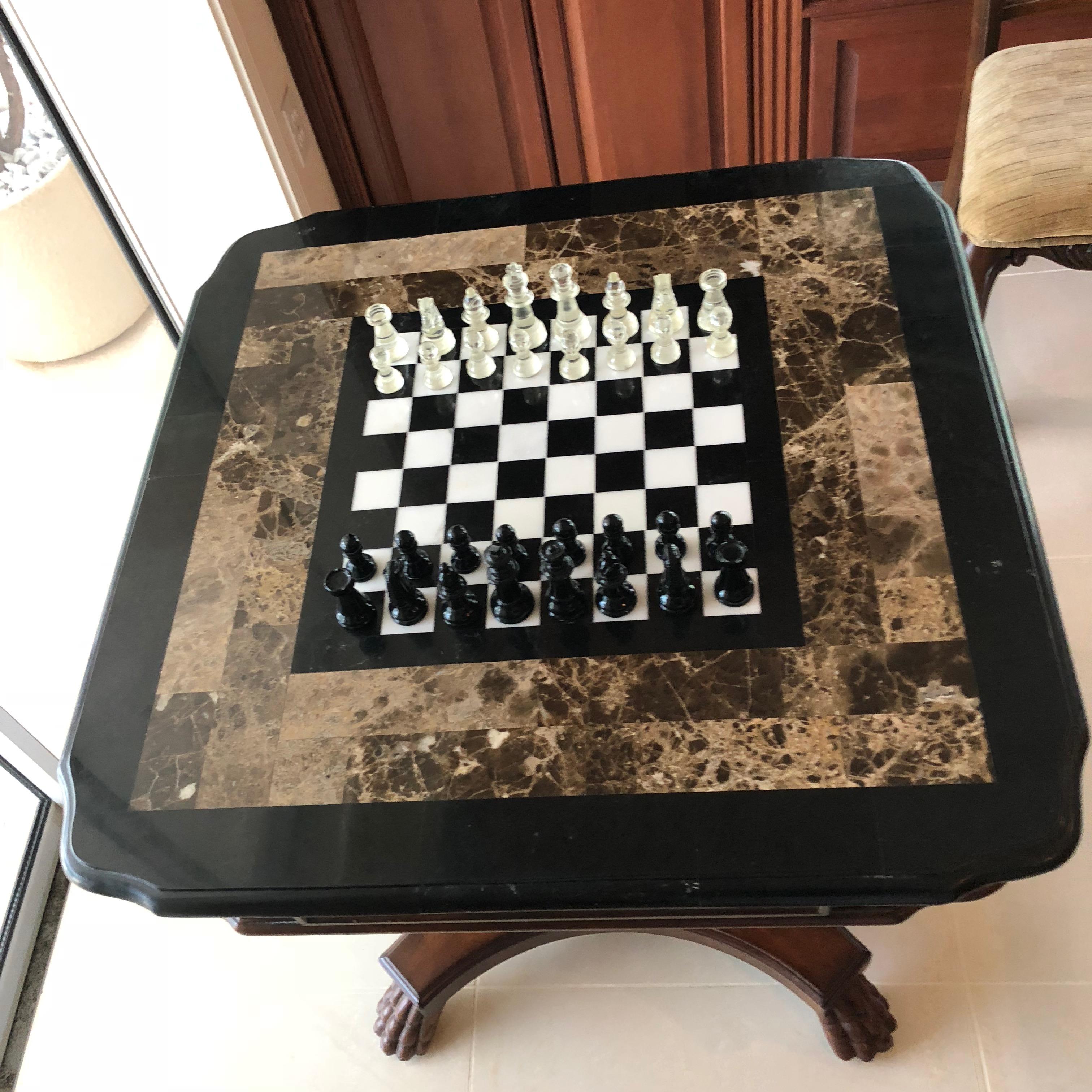 This well created game table hand-carved from mahogany with an inset marble playing board from Chess, etc. Having one drawer at the apron, carved pedestal table ending with four claw feet.