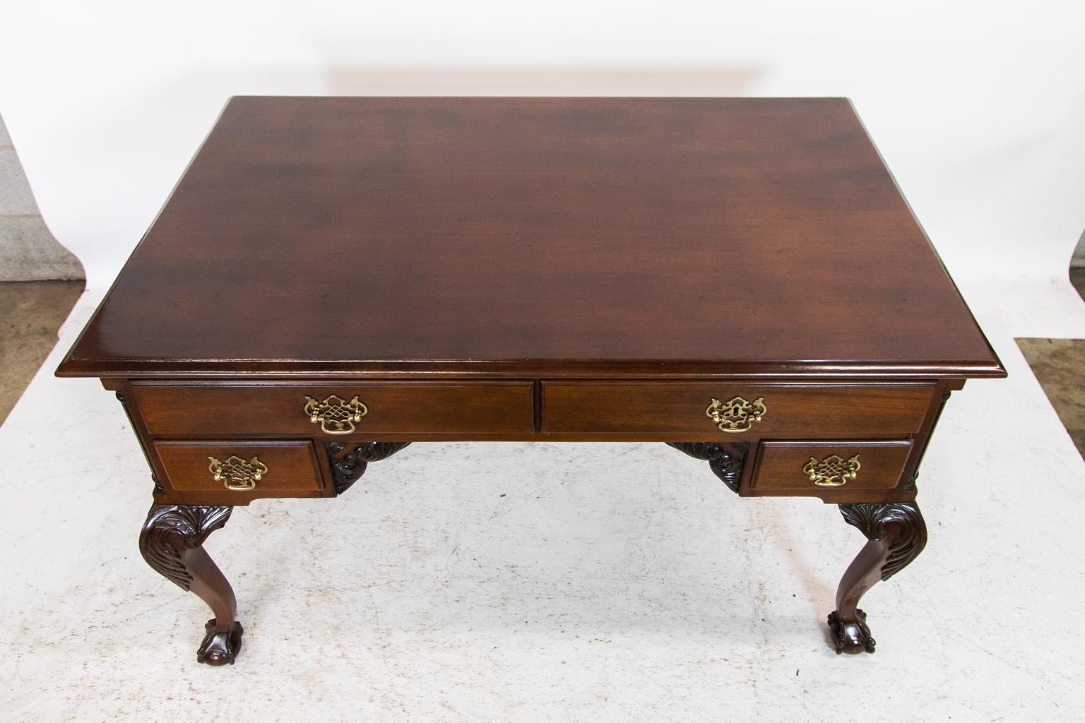 This writing desk is finished on all four sides. The ends have fluted quarter columns. The legs and knuckles have acanthus leaves carved in high relief and terminate in ball and claw feet. The side aprons have carved arabesques. One side has all