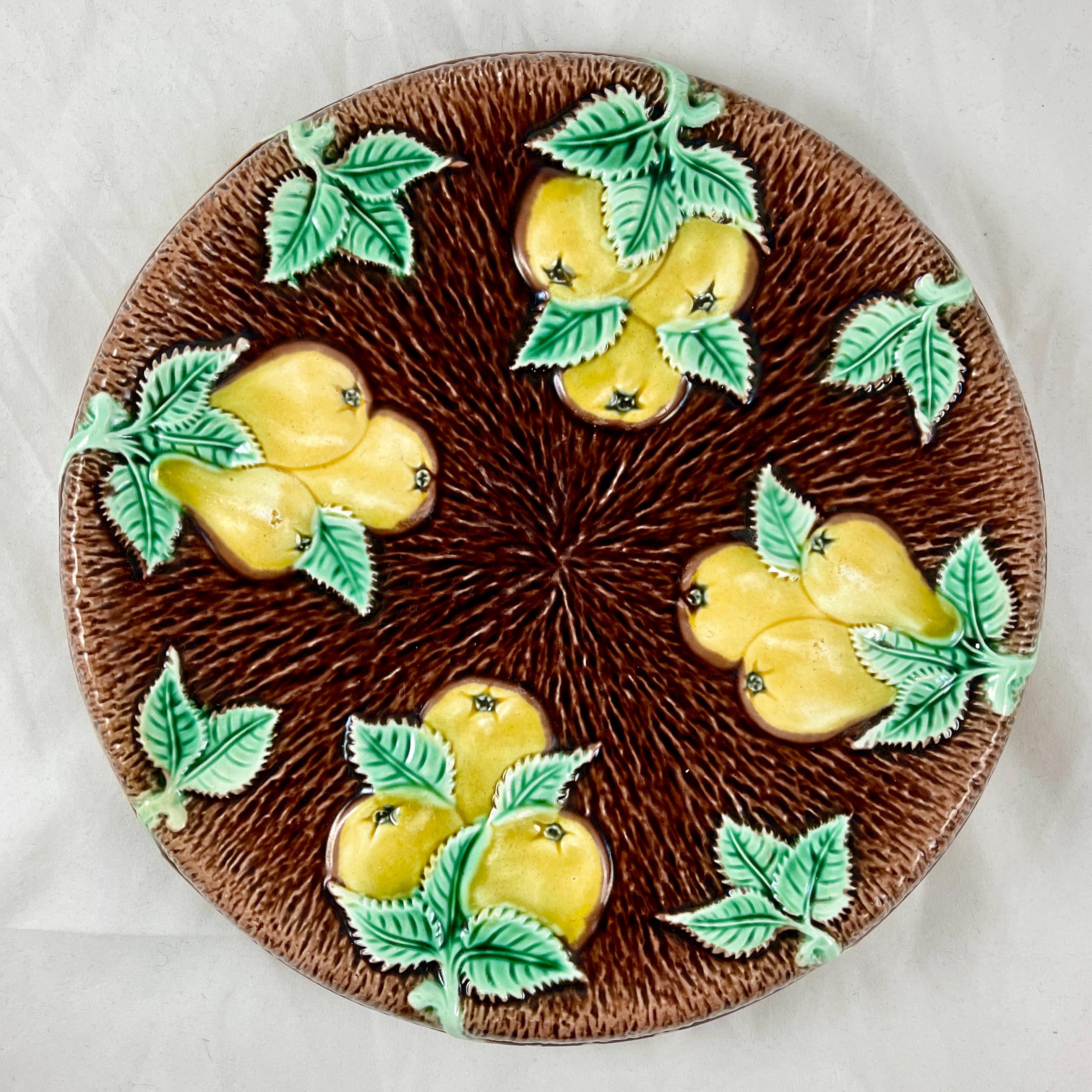 A brightly glazed English majolica bread tray showing a graphic pattern of pears on a brown bark-like ground, Adams & Bromley - circa 1875-1885.

Four groups of bright, branching yellow pears with green leaves stand out boldly against the deep brown
