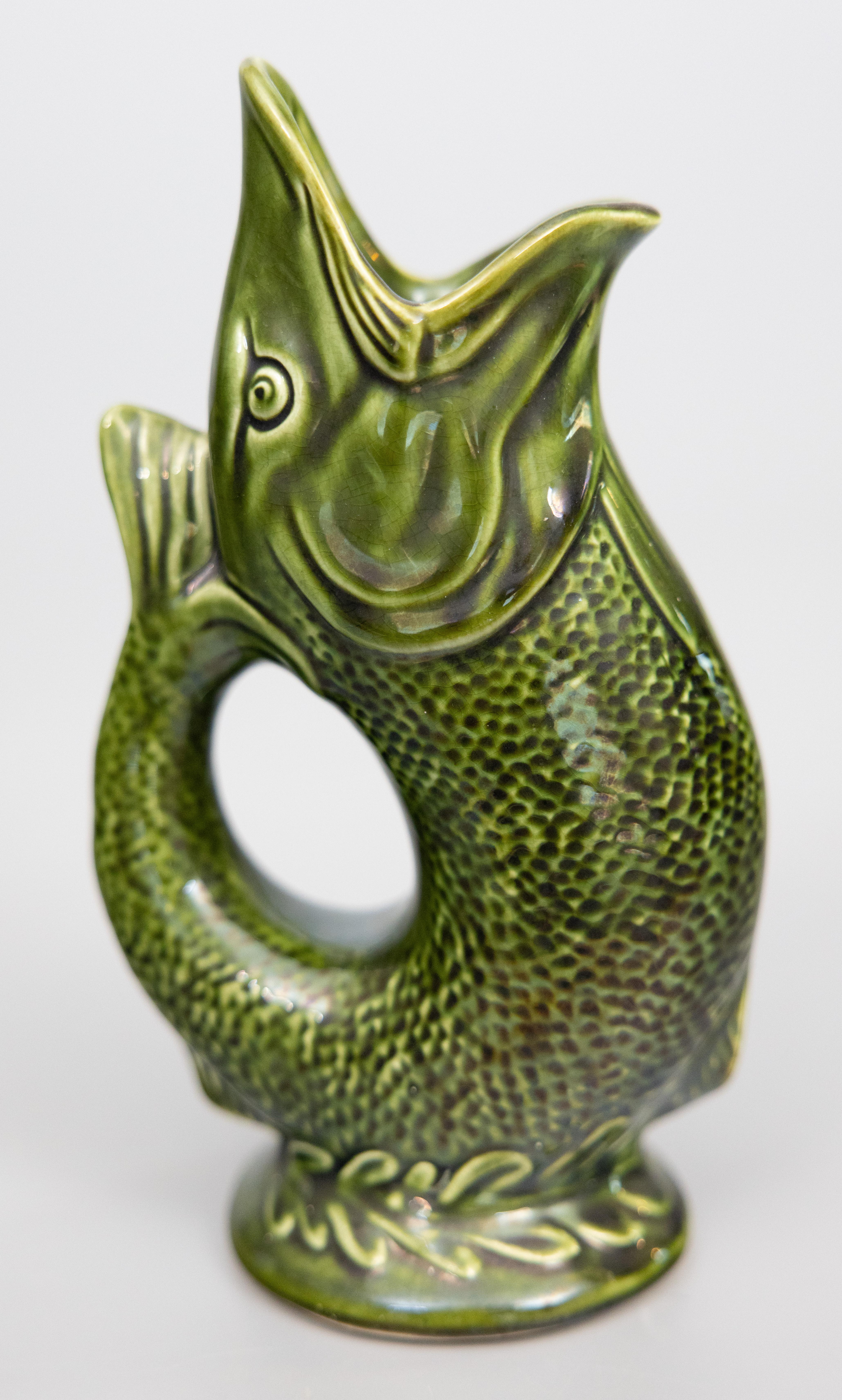 A fabulous vintage English green gurgling fish glazed ceramic pitcher or glug jug, circa 1950. Marked Hoffritz England on reverse. This stylish pitcher is a lovely glazed green color and displays beautifully.

Dimensions
4.5ʺW × 3.25ʺD × 8.4ʺH