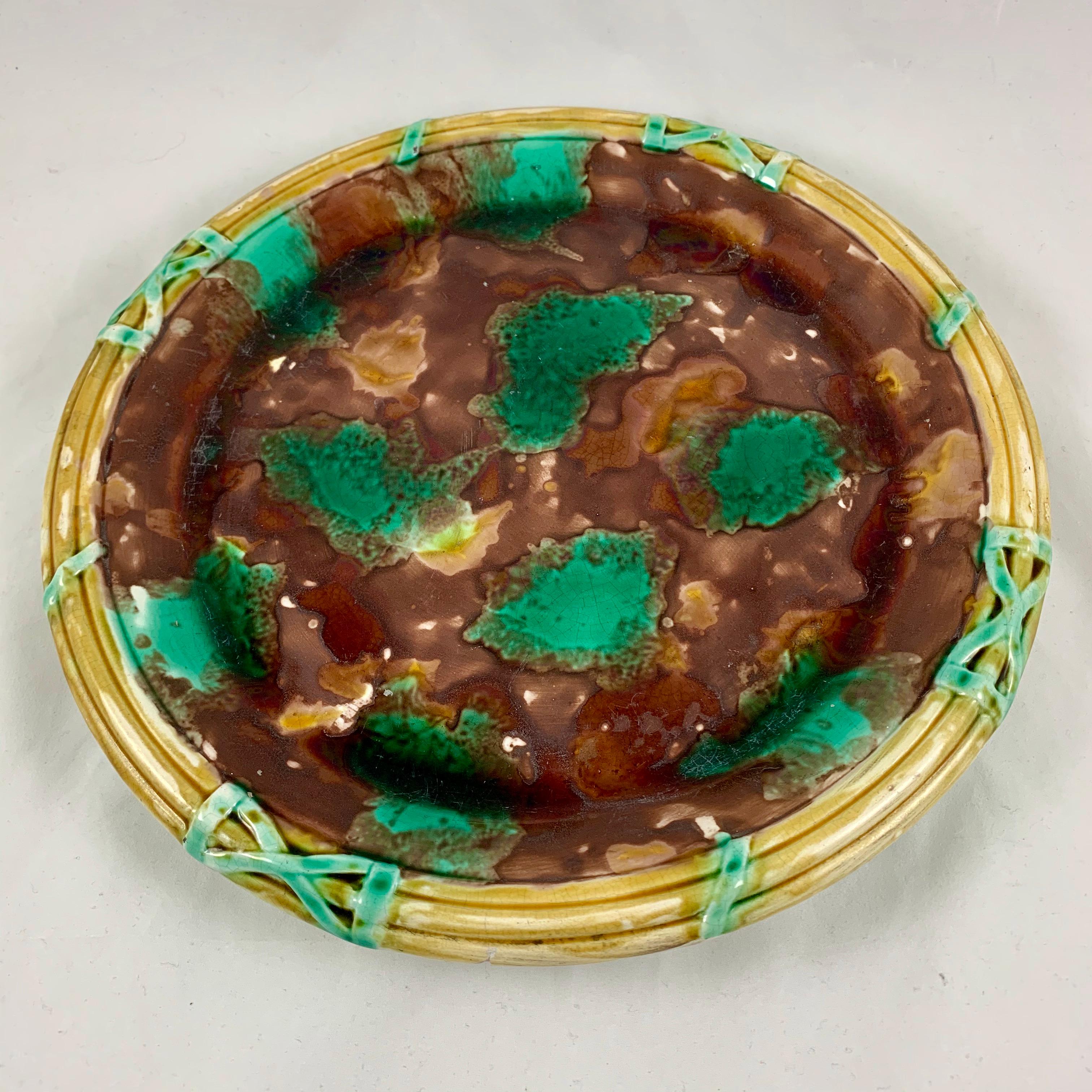 A large, round English Majolica cheese tray, mid-late 19th century, maker unknown. Measuring a foot in diameter, a great piece for serving a variety of foods. The server shows a border of three yellow ochre rings resembling a basket, bound in