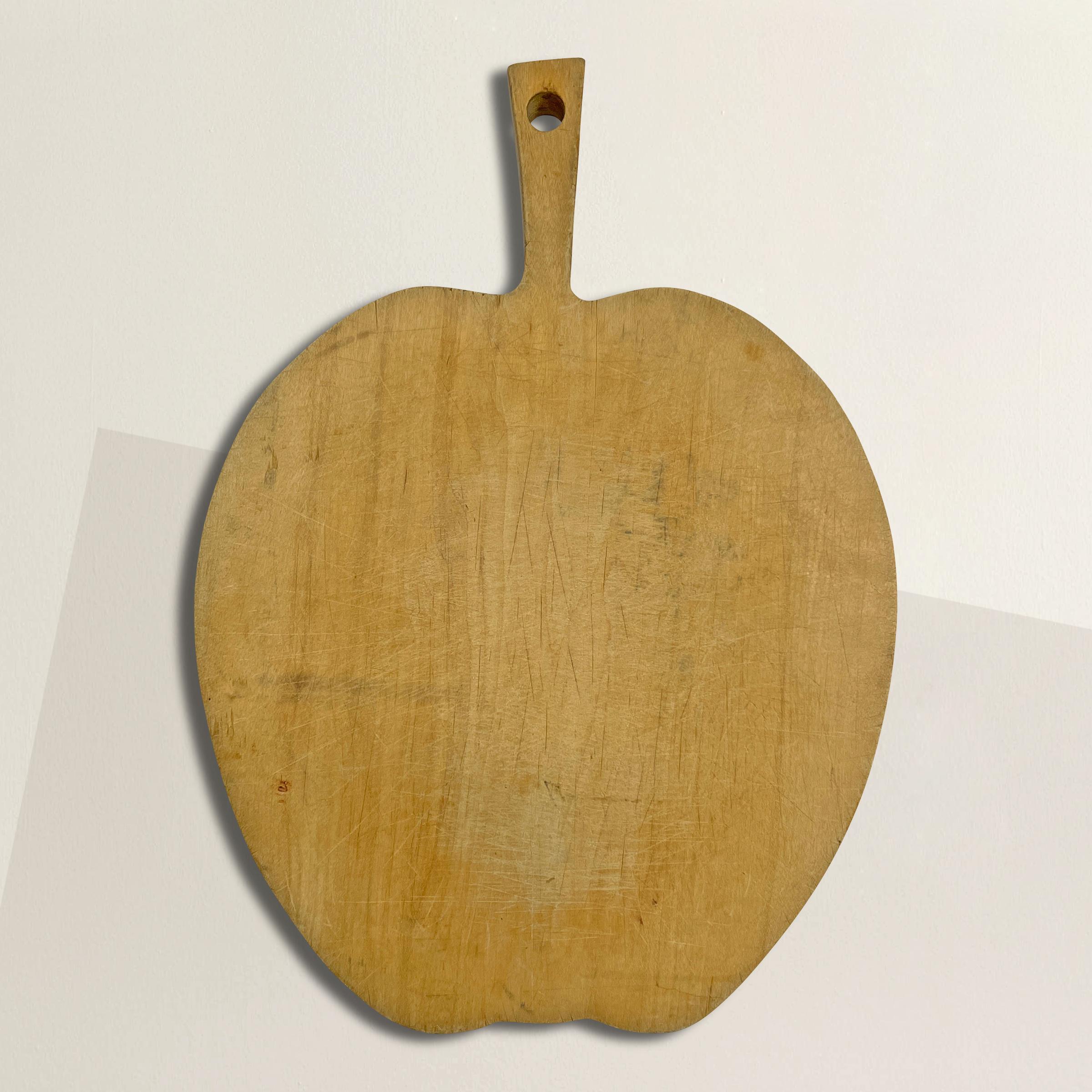 A quaint early 20th century English maple apple cutting board perfect for chopping fruits and veggies, or serving charcuterie at your next lunch party.
