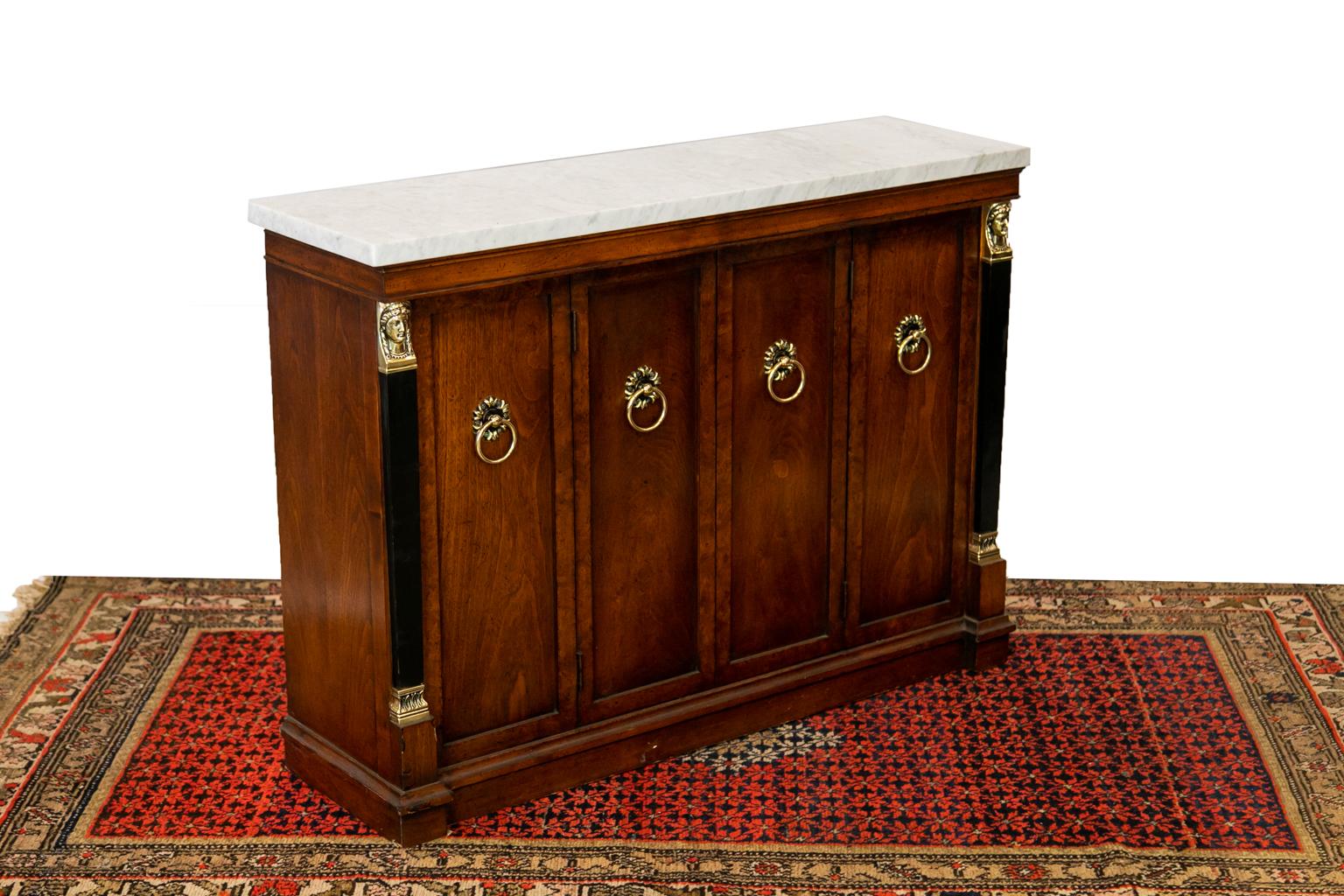 This Regency style server has a white Carrera marble top. The brasses are original and are polished and lacquered for ease of maintenance. The two center doors open to expose the interior cabinet which has one adjustable shelf.