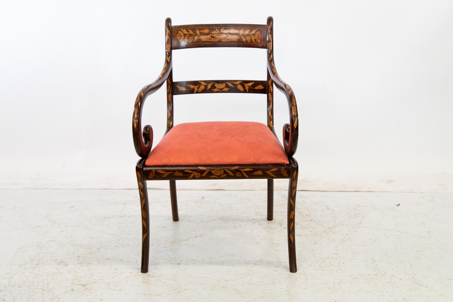 This English marquetry armchair is profusely inlaid all-over with satinwood and boxwood leaf, vine, and arabesque inlays. The seat has been newly recovered with a coral damask.