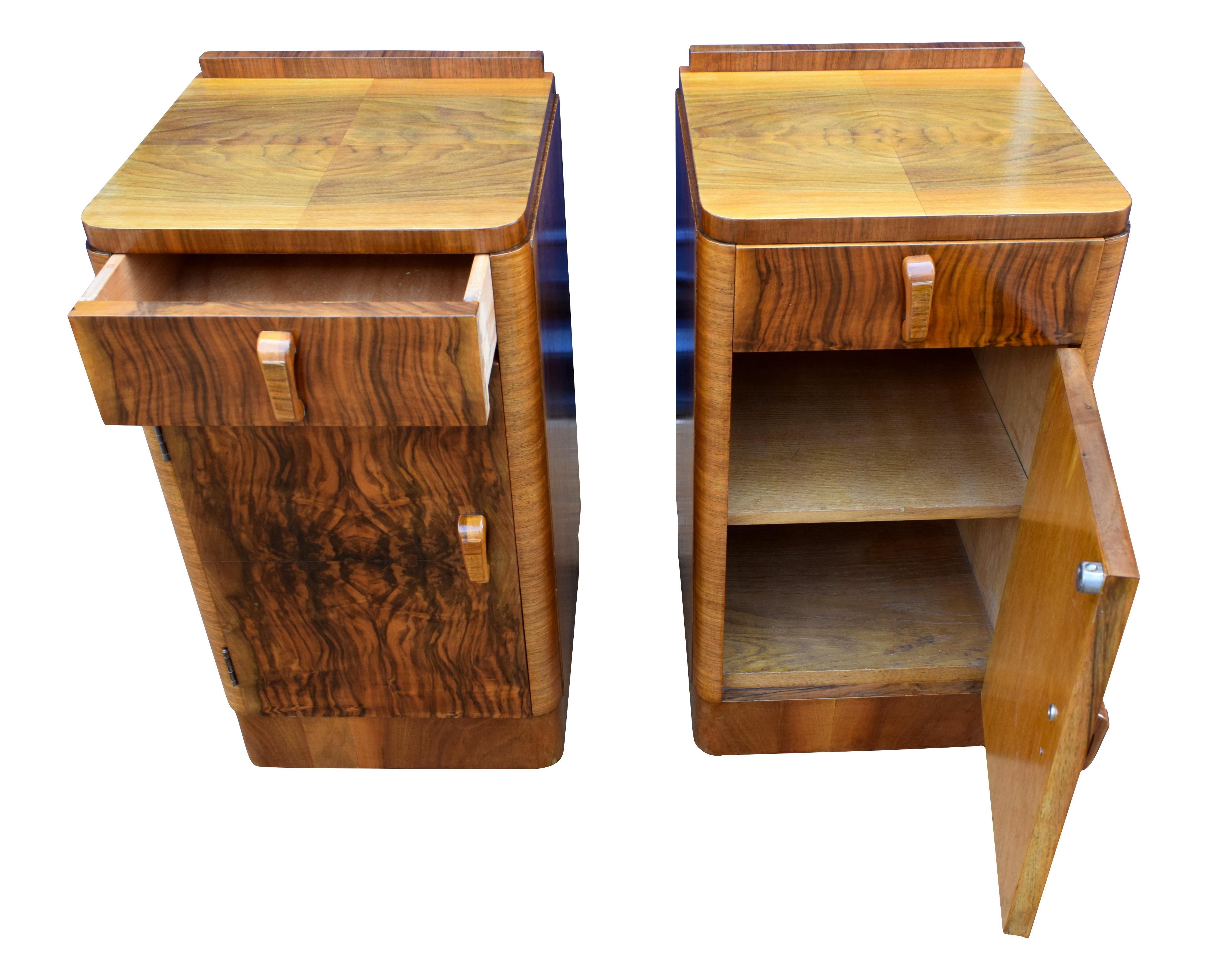 Fabulous pair of matching 1930s Art Deco bedside tables in heavily figured walnut veneer. Two generously sized internal storage areas. Each cabinet has a pullout / pull-out upper drawer which works effortlessly. We've had both cabinets fully and