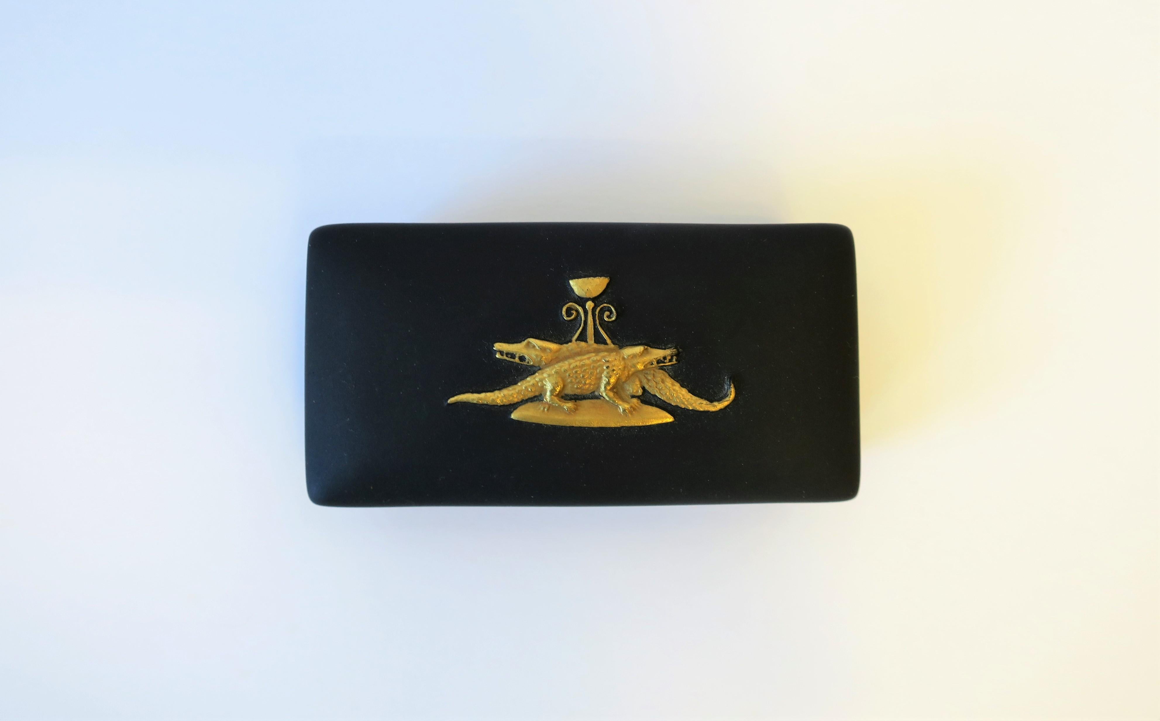 A chic and rare English Jasperware matte black basalt and gold box, by Wedgwood, England. A very beautiful small box with a gold raised relief of two alligators or crocodiles. Box is beautiful as a standalone piece or for small jewelry or other