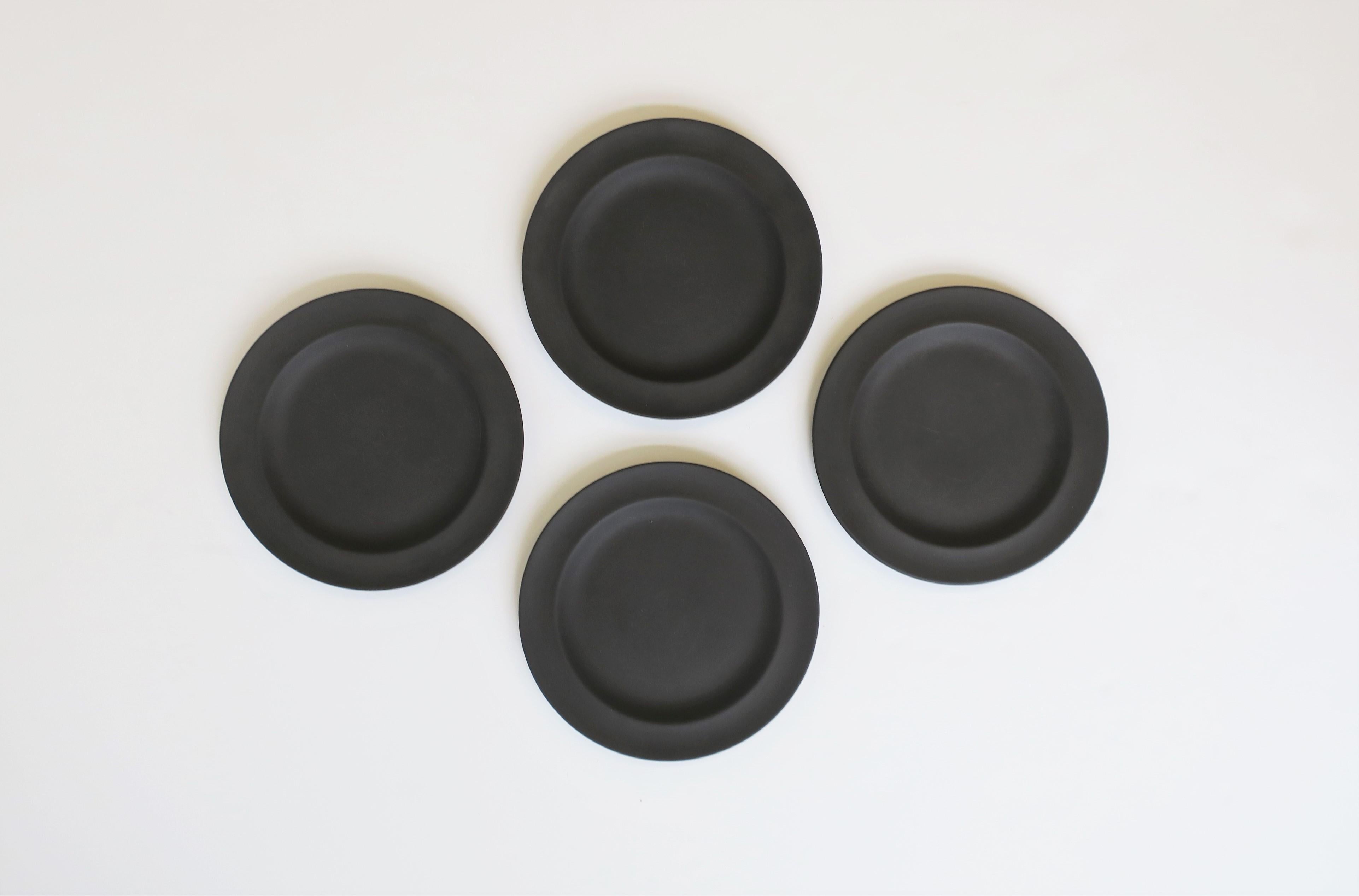 A beautiful set of four (4) English Jasperware matte black basalt plates by Wedgwood, England, 1970. With maker's mark on bottom of all four plates: 