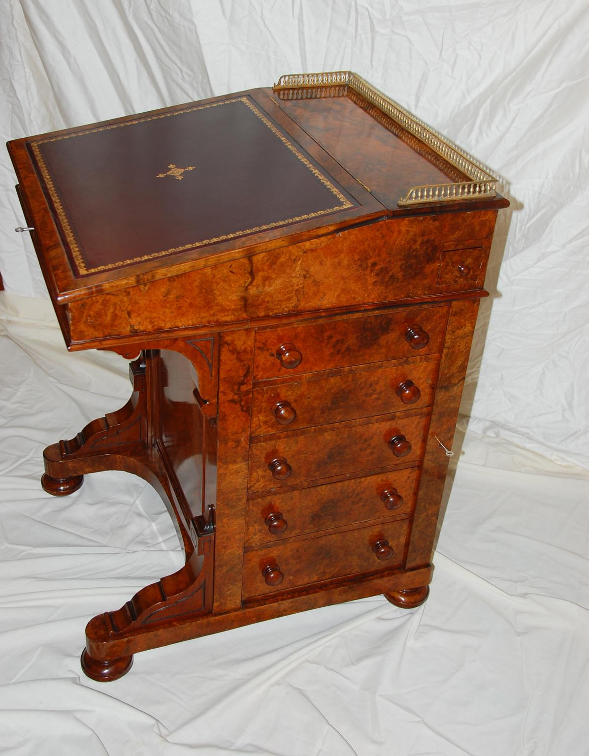 English mid-19th century burl walnut davenport desk with Wellington locking bar for the five side drawers (one key locks all the drawers at the same time) on the right hand side. The left side has sham drawers. There is also a small drawer that