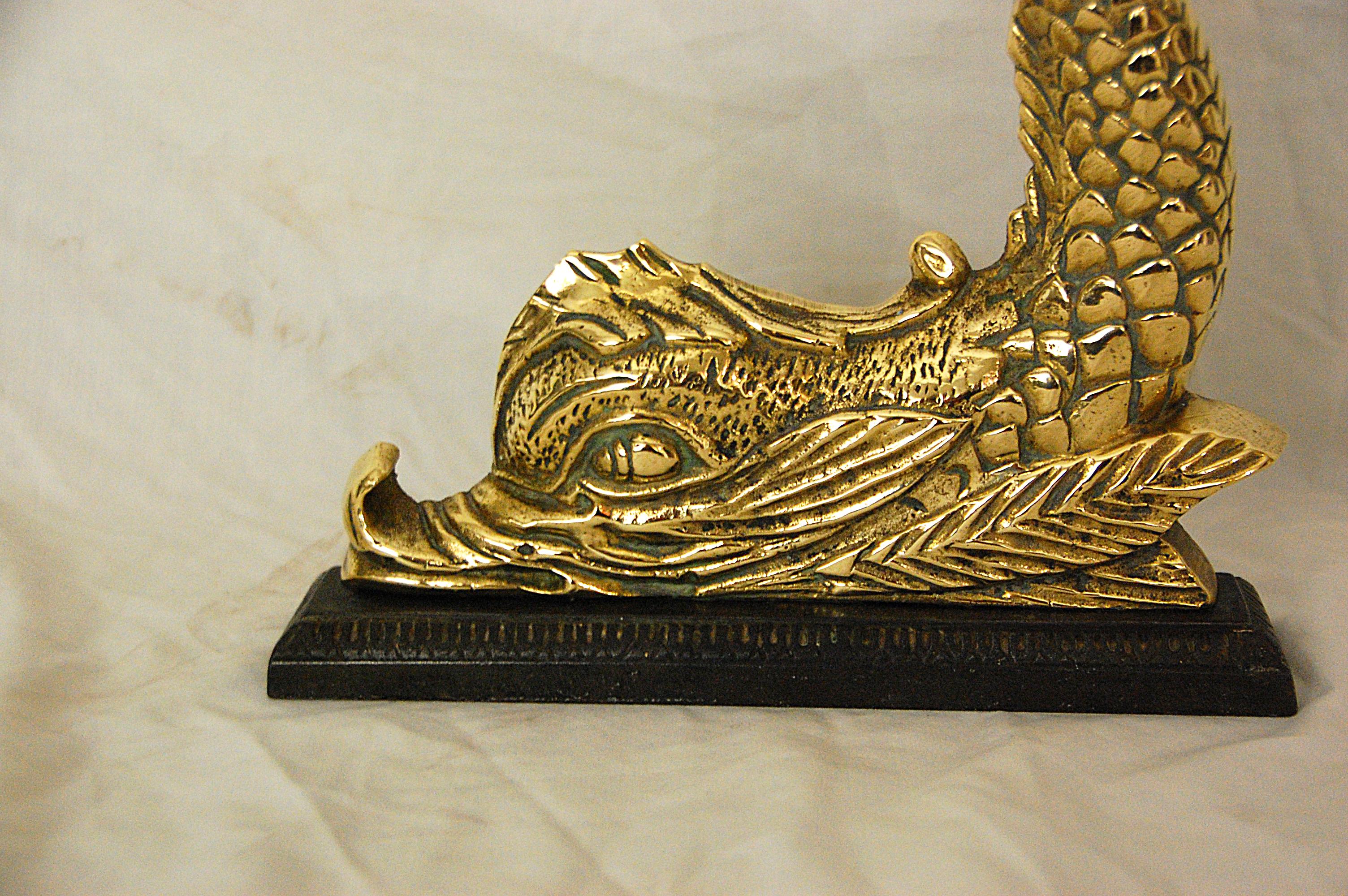 English mid-19th century cast brass dolphin doorstop on original cast iron plinth. This heavy quality well detailed dolphin has his tail curled around in a circle so he is easy to pick up and move and is a wonderful doorstop. If one is searching for