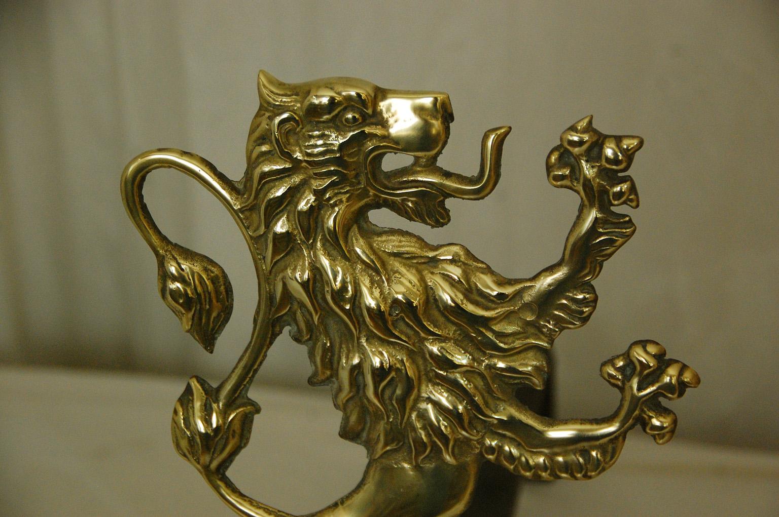 English or possibly American mid 19th century cast brass rampant lion andirons with iron log holders, and cast brass log stops. These beautifully cast lions are finely detailed. The iron log holders have been replaced sometime within the last 100