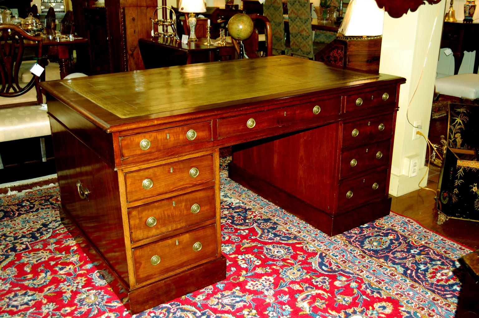 English mid 19th century mahogany pedestal partners desk with drawers and cupboards.  This classic partners desk comes in three parts, as most desks made in the earlier part of the 19th century did.  The top has three drawers on each long side. 