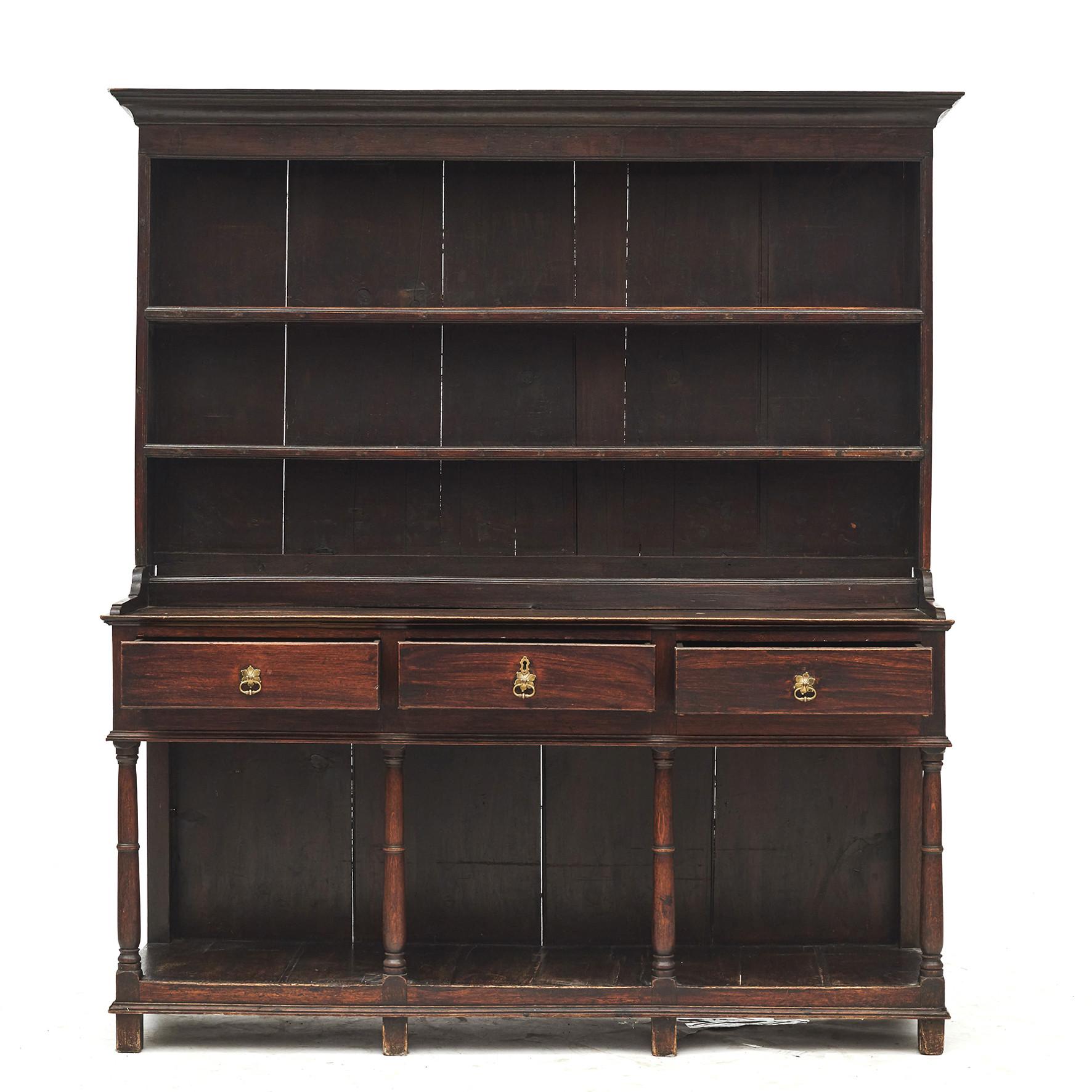 English Georgian style oak Welsh dresser.
Two top shelves / plate rails above three middle drawers supported by turned columns on lower shelf.
In original untouched condition.
England, mid-19th century.