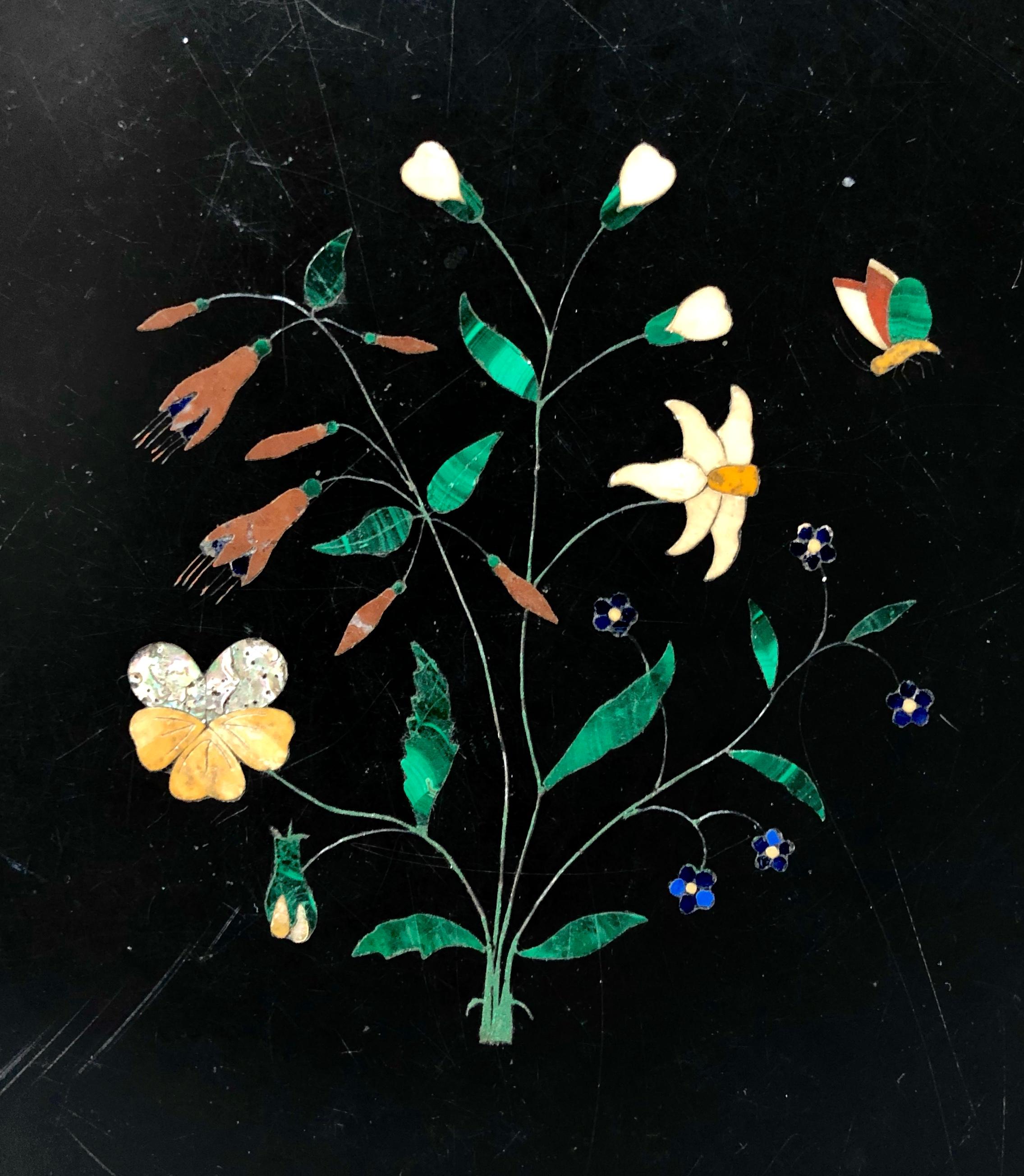 Eine englische achteckige Tischplatte aus schwarzem Marmor mit Intarsien aus Pietre dure aus der Mitte des 19. Jahrhunderts von William Adam für das Ashford Works and Old Royal Museum, Matlock
Im Zentrum ein Blumenzweig mit einem Schmetterling,