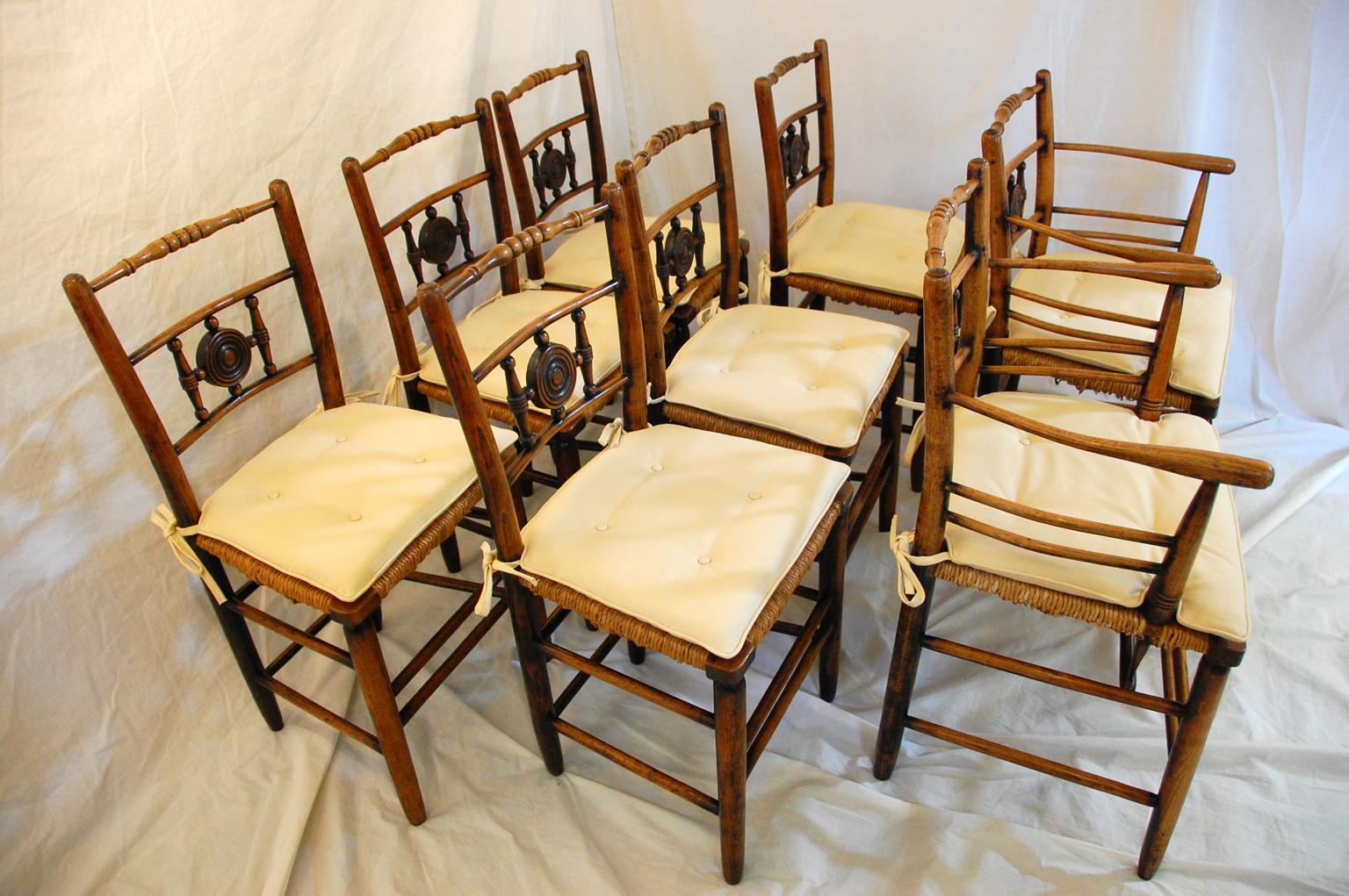 English mid-19th century set of eight Sussex elm dining chairs, consisting of two armchairs and six side chairs. This is an unusual model of the Sussex chair as it has the interesting turned center sphere to the back (most just have spindles). The