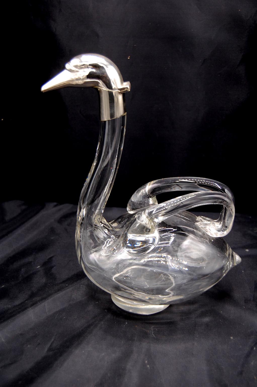  English pair of swan free blown glass decanters with silver plated head and neck.  These mid 20th century decanters are works of art.  The wings are the handles for pouring, each swan is slightly different, as if they are talking to each other, the