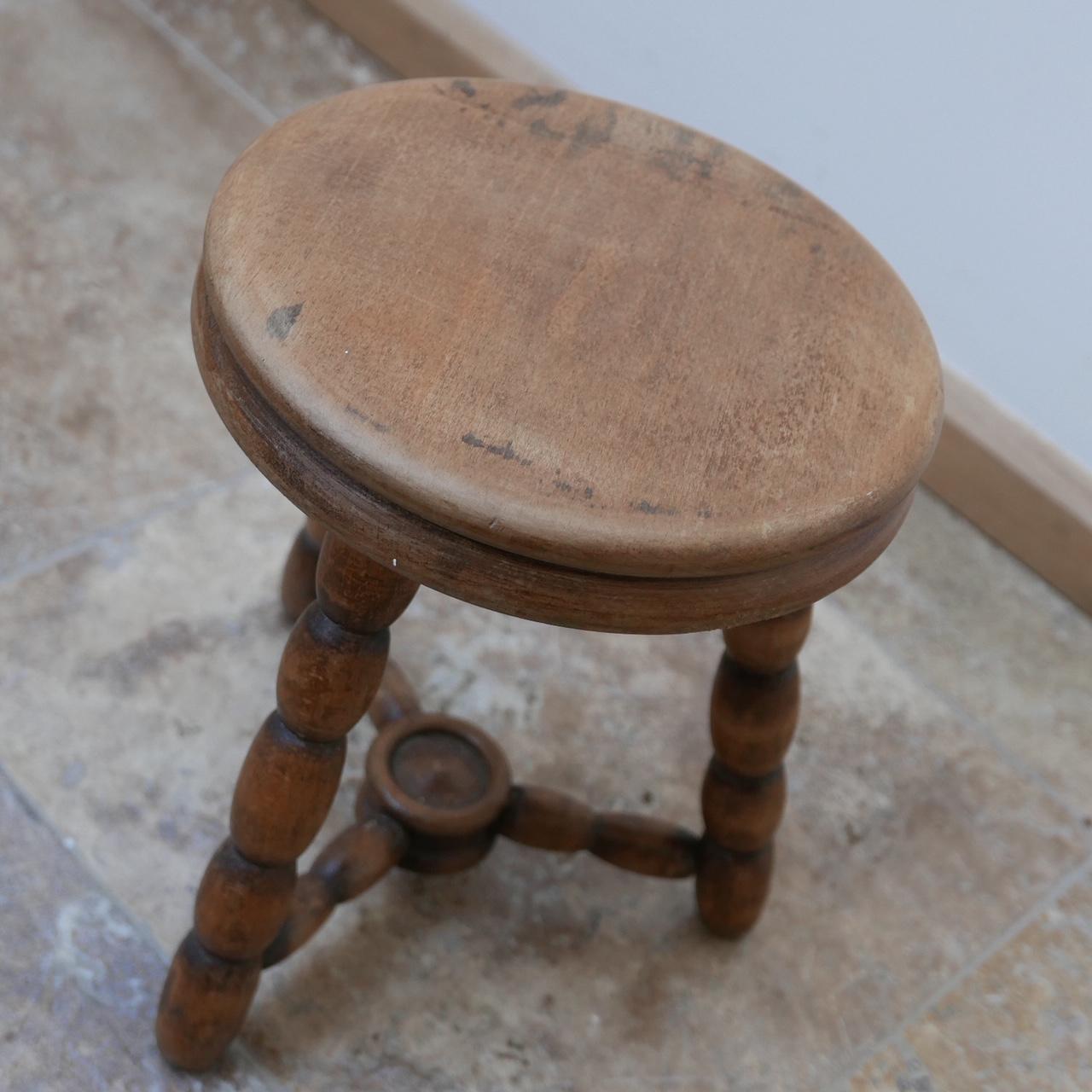 A stylish bobbin style low wooden stool, ideal for use as a low side table.

English, circa 1950s.

Patina and evidence of wear but generally good condition.

Dimensions: 25 diameter x 30 height in cm.