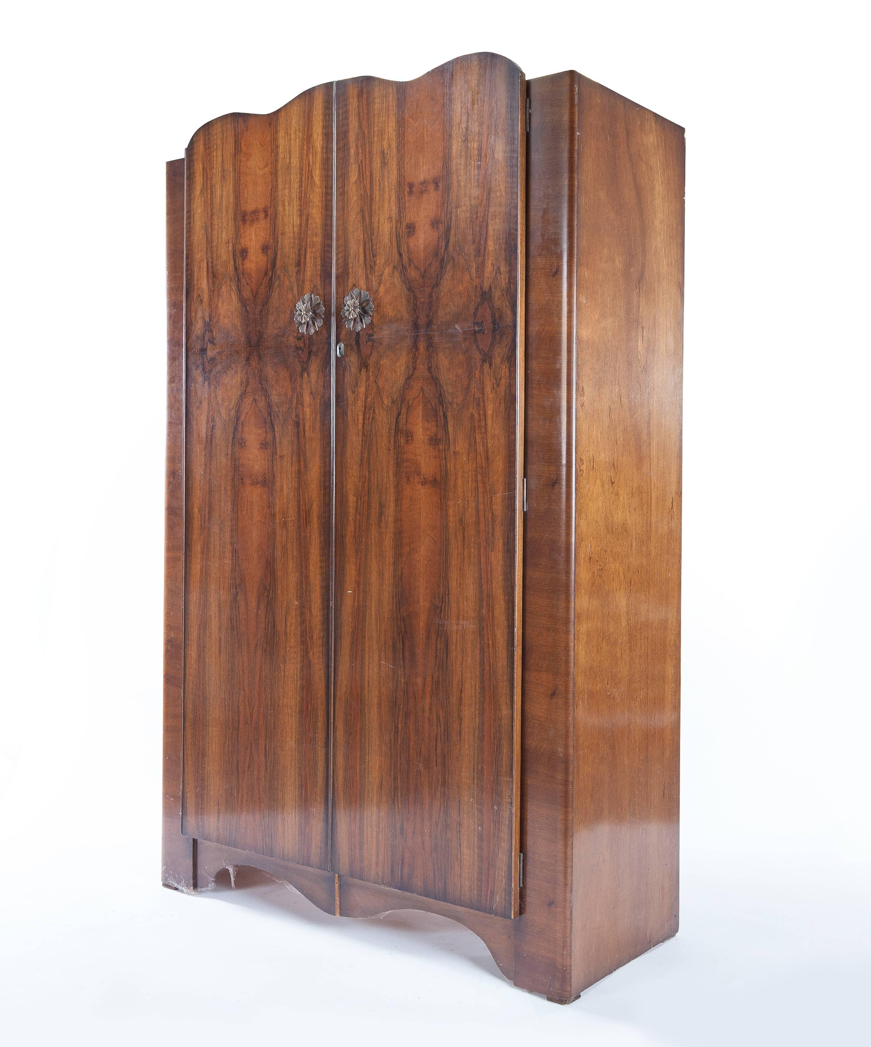 An English Mid-Century Modern deco armoire. It features a beautiful book match veneer. The armoire measures approximately 48