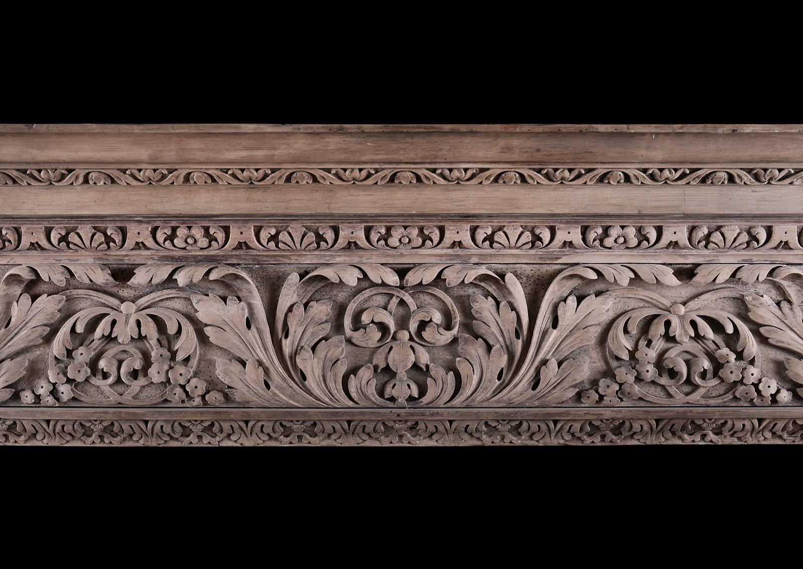 A large English carved pine mid-Georgian fireplace. The ogee shaped frieze with flowers and scrolled leafwork detail, and leaf inner moulding to frieze and breakleg jambs. The inverted breakfront shelf with carved foliage and flower mouldings, 18th