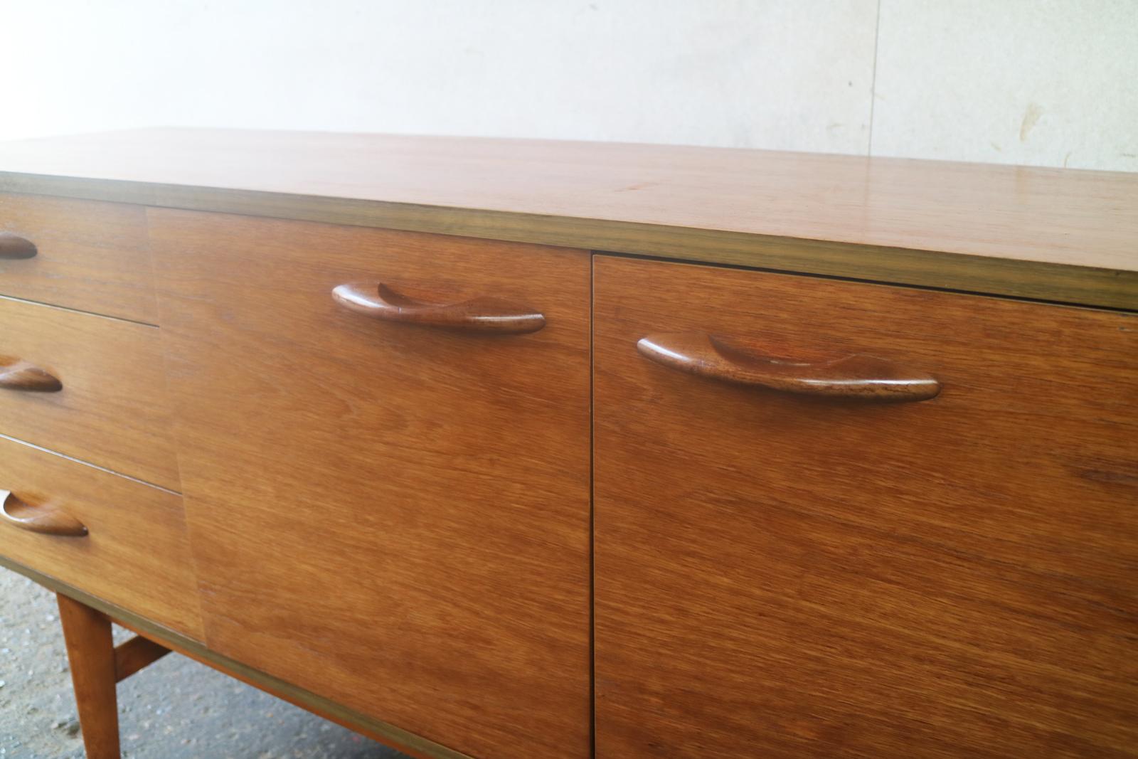 A lovely Danish influenced sideboard by English Maker Avalon. Beautiful wood grain and slim restrained curved handles.




 