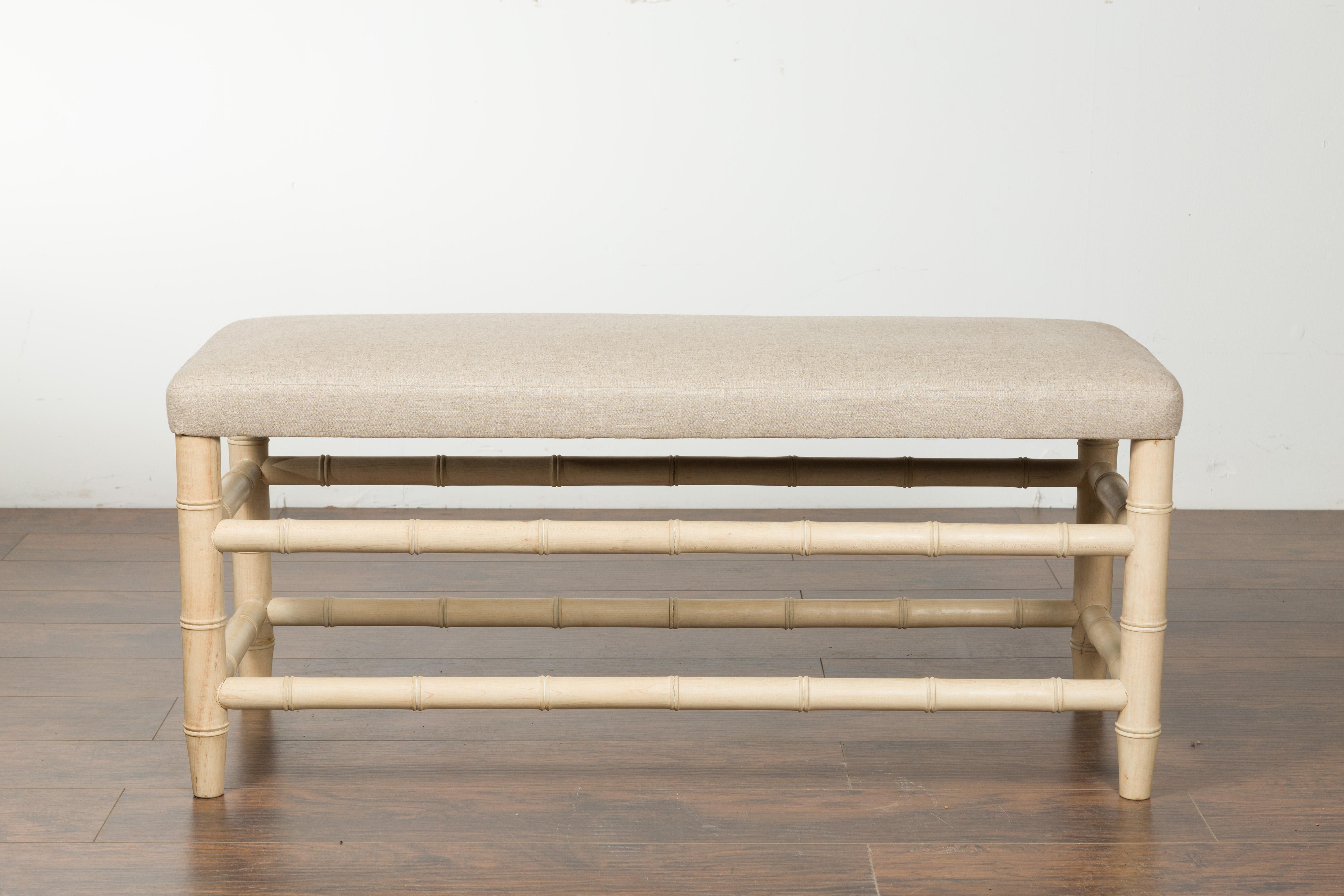 An English vintage bleached walnut faux bamboo bench from the mid-20th century, with new upholstery. Created in England during the midcentury period, this bleached walnut bench features a rectangular seat newly recovered with a neutral toned linen