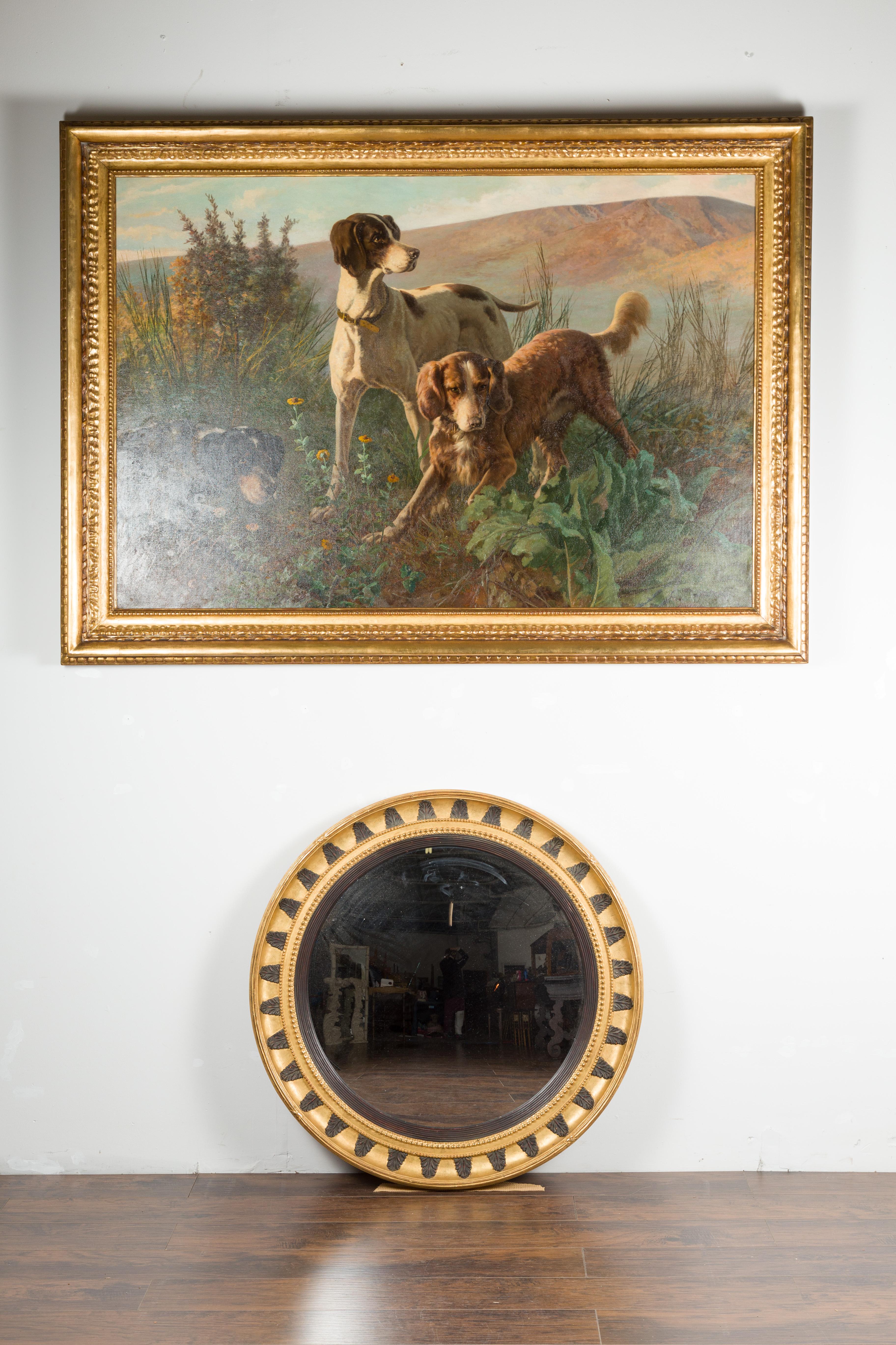 An English bullseye convex gilded mirror from the mid-20th century, with ebonized acanthus leaves and beads. Created in England during the midcentury period, this bullseye mirror features a circular gilded frame, perfectly adorned with carved and