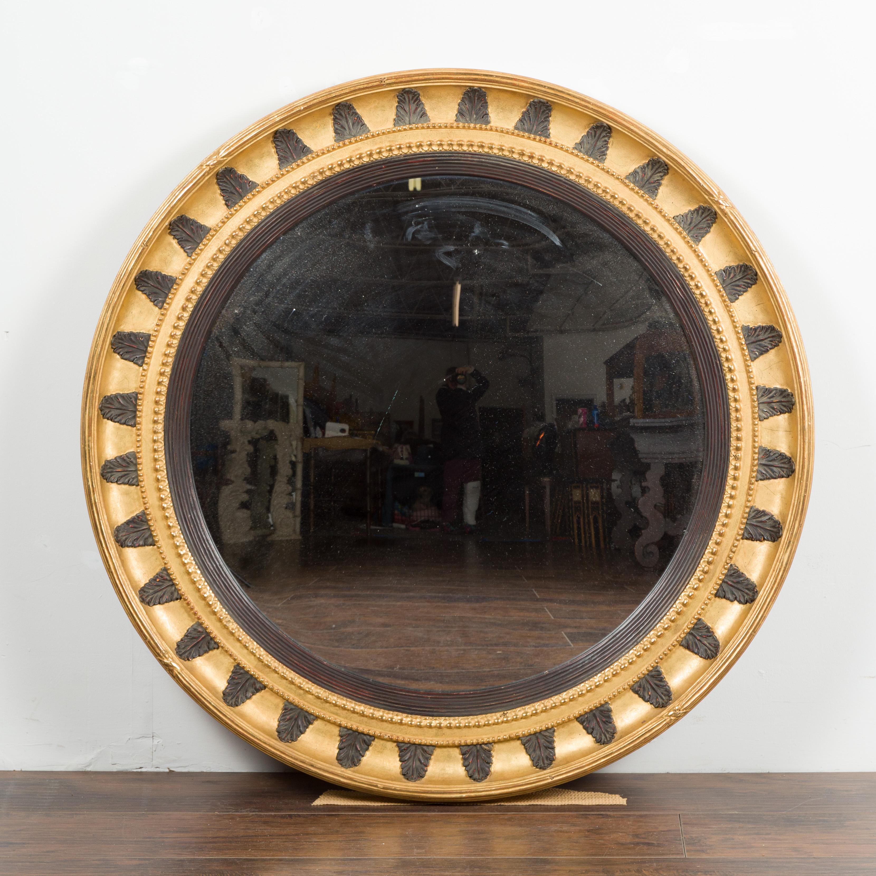 Carved English Midcentury Bullseye Convex Mirror with Gilded Frame and Ebonized Leaves