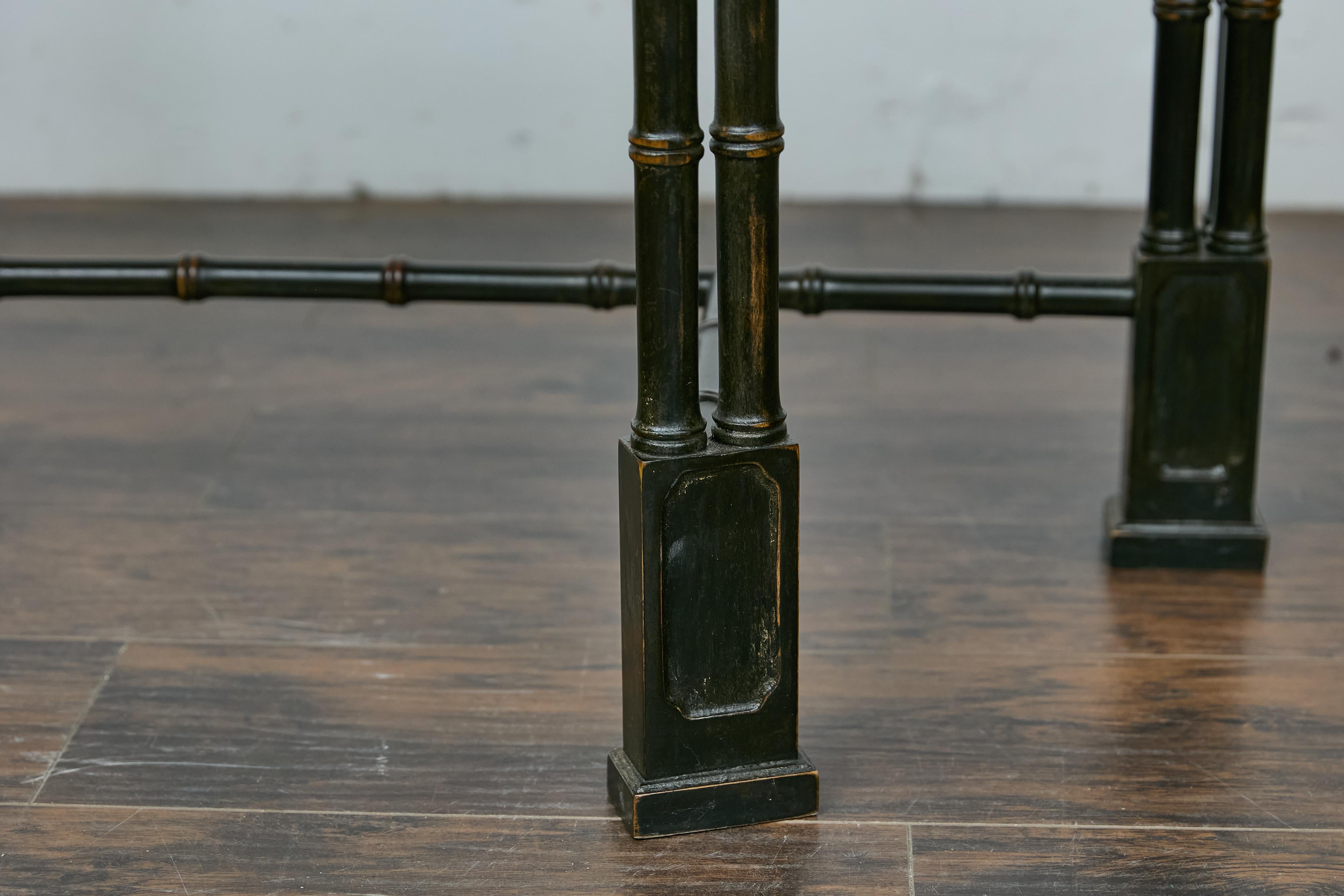 An English Midcentury demi-lune console table with ebonized faux-bamboo base and white veined marble top. This English Midcentury demi-lune console table showcases an elegant juxtaposition of materials and colors, making it a striking addition to