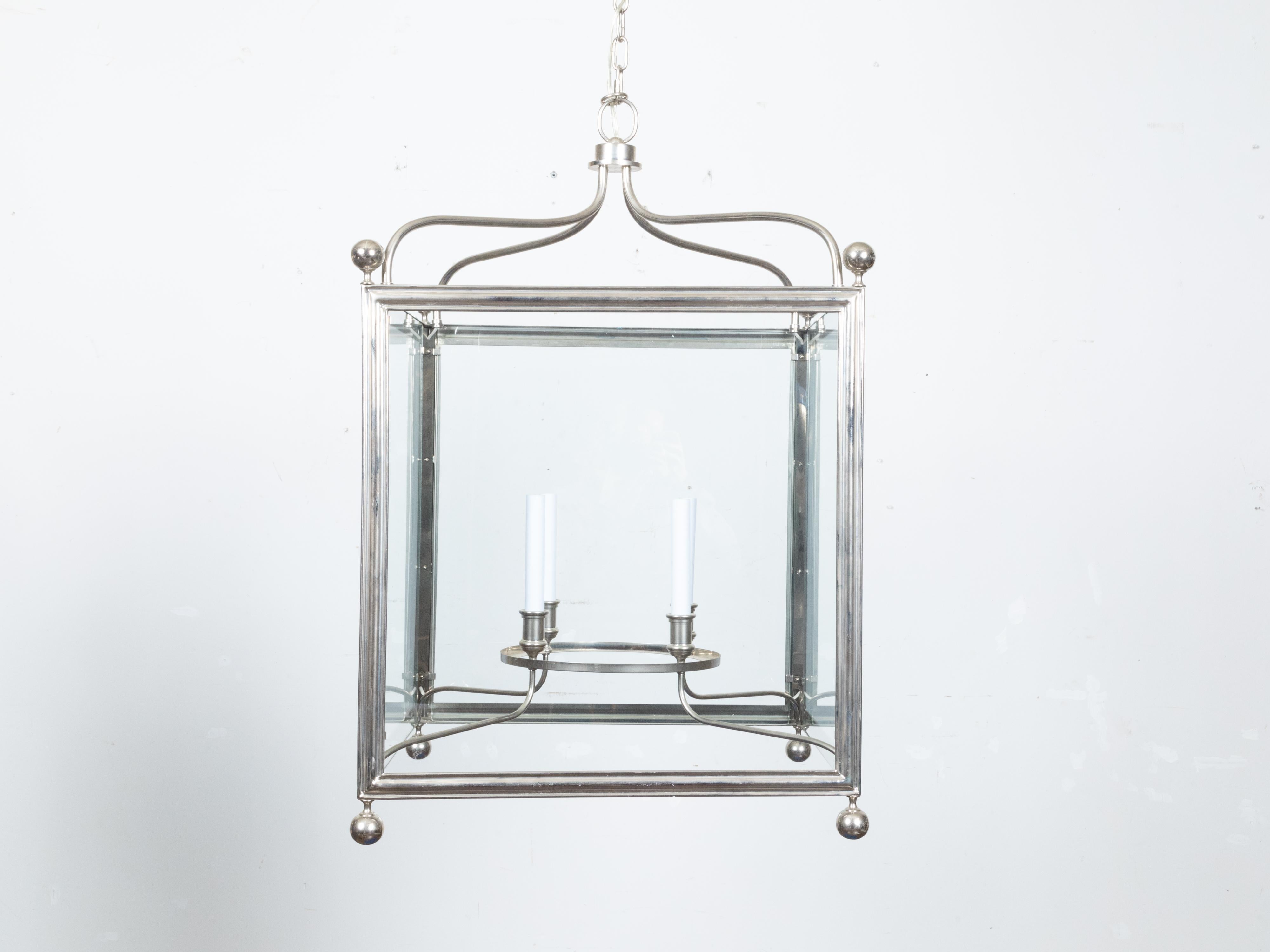An English Midcentury metal four-light lantern with silver color, scrolling accents and glass panels. Introduce an elegant statement to your interiors with this English Midcentury metal four-light lantern. Crafted circa mid-20th century, this