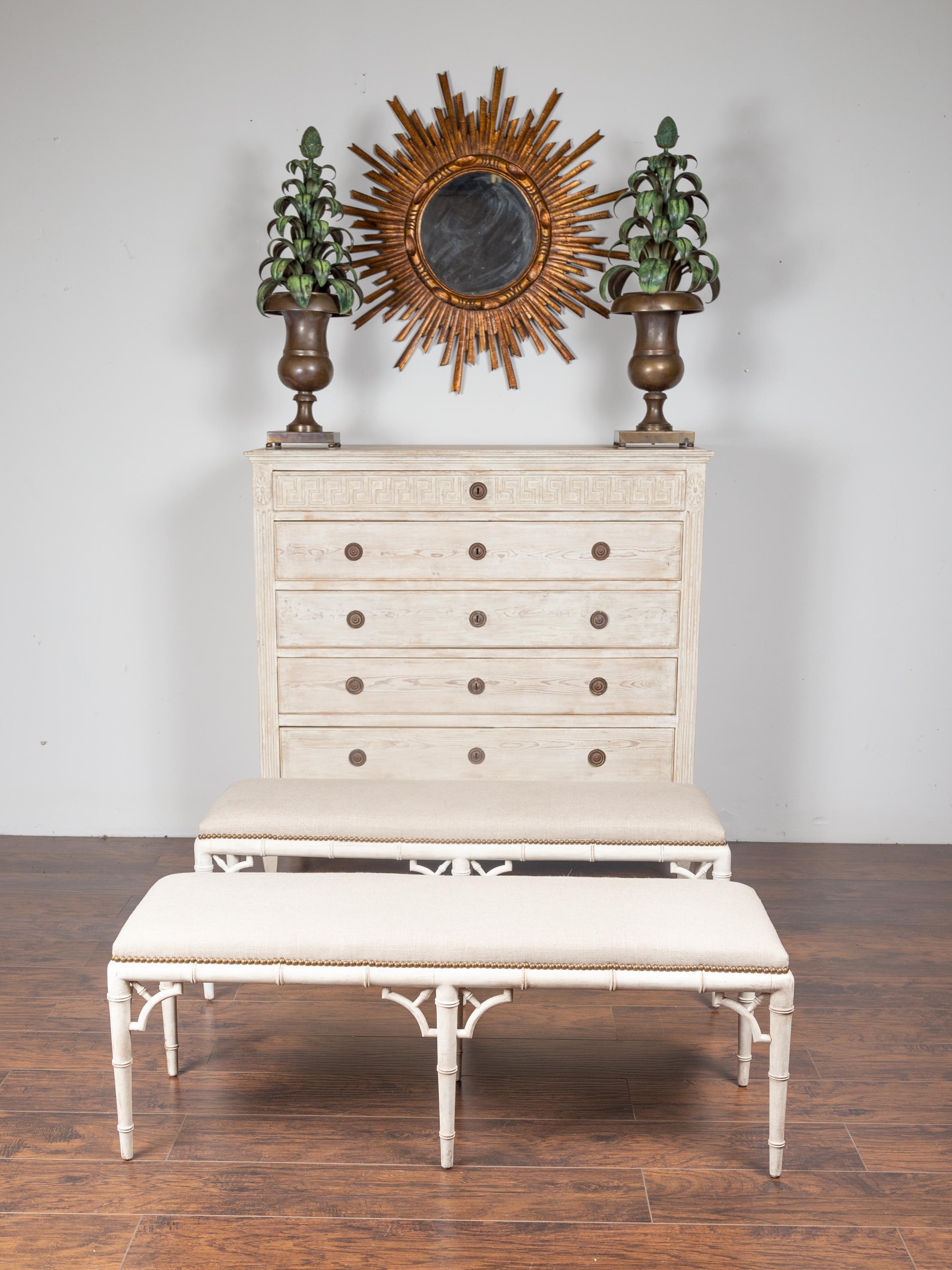 An English vintage painted faux bamboo bench from the mid-20th century, with newly reupholstered seat. We have two available that would make for a great pair, but they are priced and sold individually. Born in England during the midcentury period,
