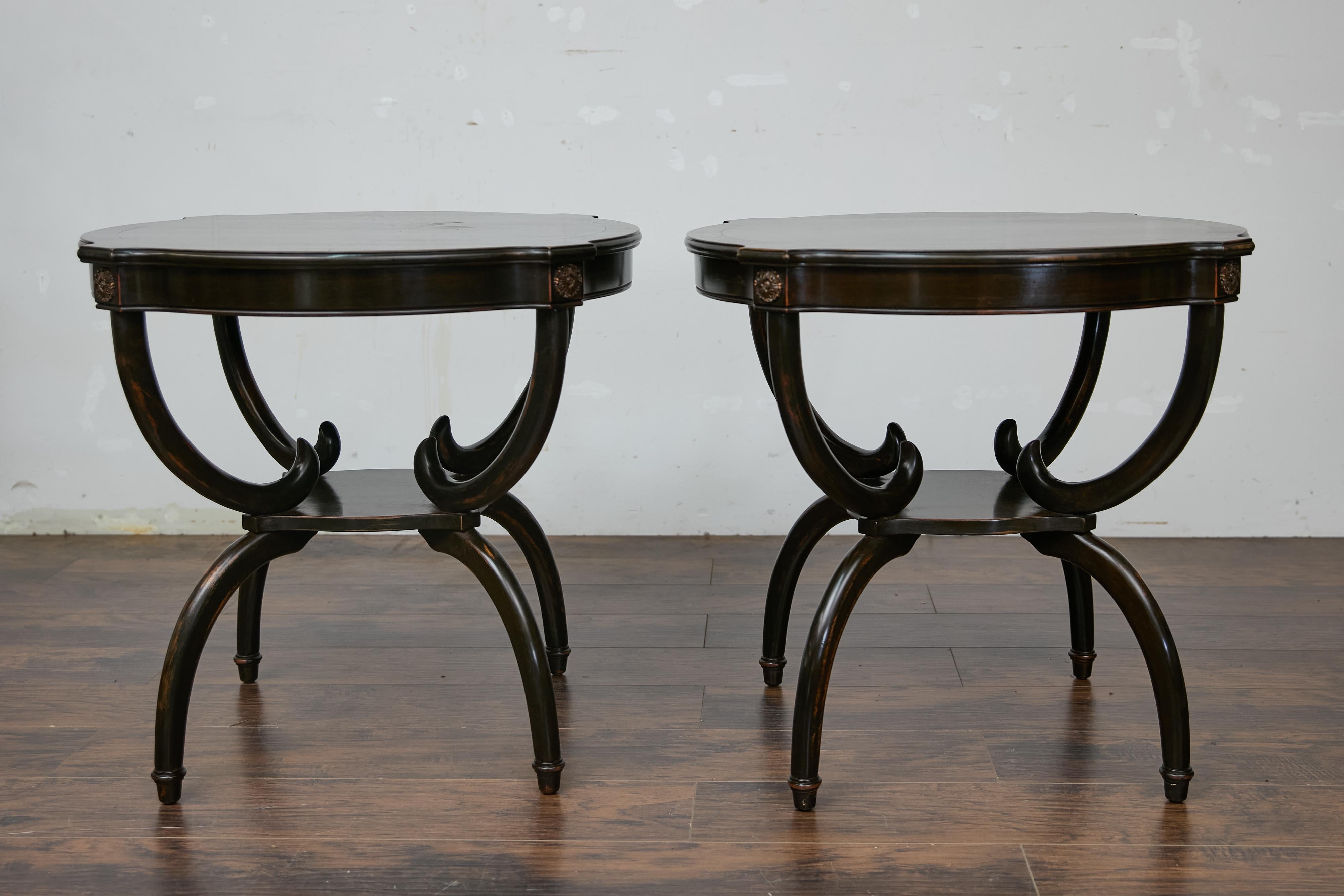 This pair of English midcentury round side tables exudes timeless elegance with their dark, nearly black-brown finish and graceful curves. Crafted from quality hardwood, likely mahogany or beech, these tables have been finished with a sleek lacquer