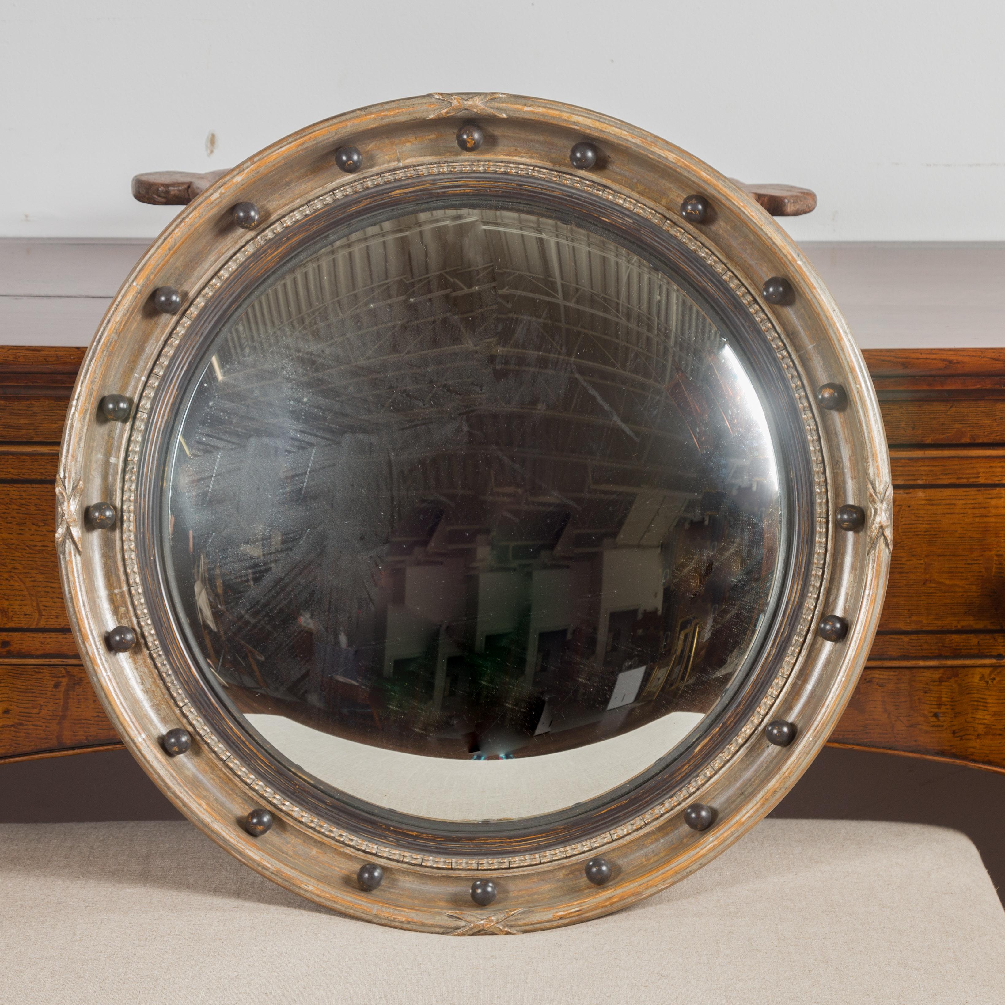 A small vintage English silver leaf convex bullseye mirror from the mid-20th century, with petite spheres and X-motifs. Created in England during the midcentury period, this silver leaf girandole mirror features a circular frame accented with petite